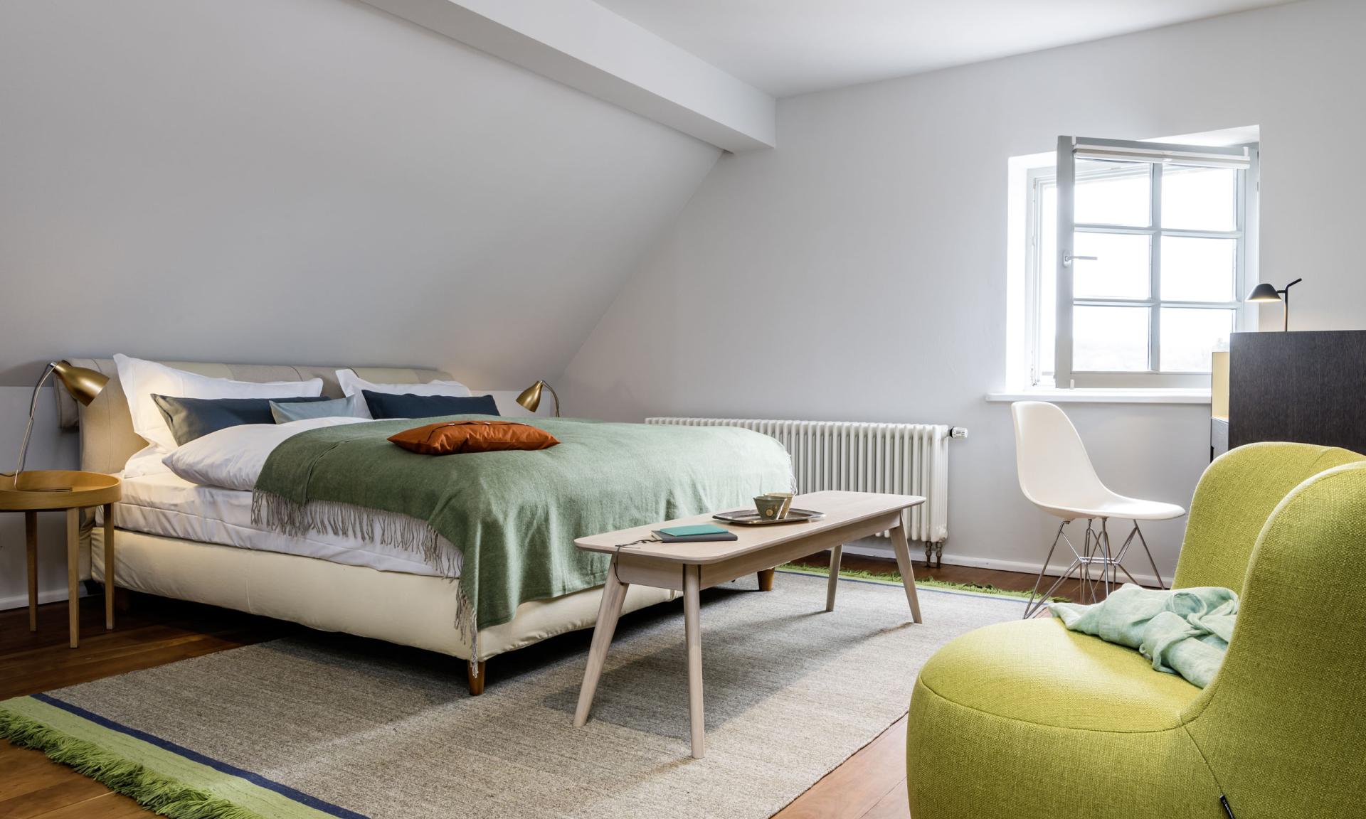 Gemütlicher Wohnbereich im Kloster Hornbach mit gelbem Sofa und blauem Sessel