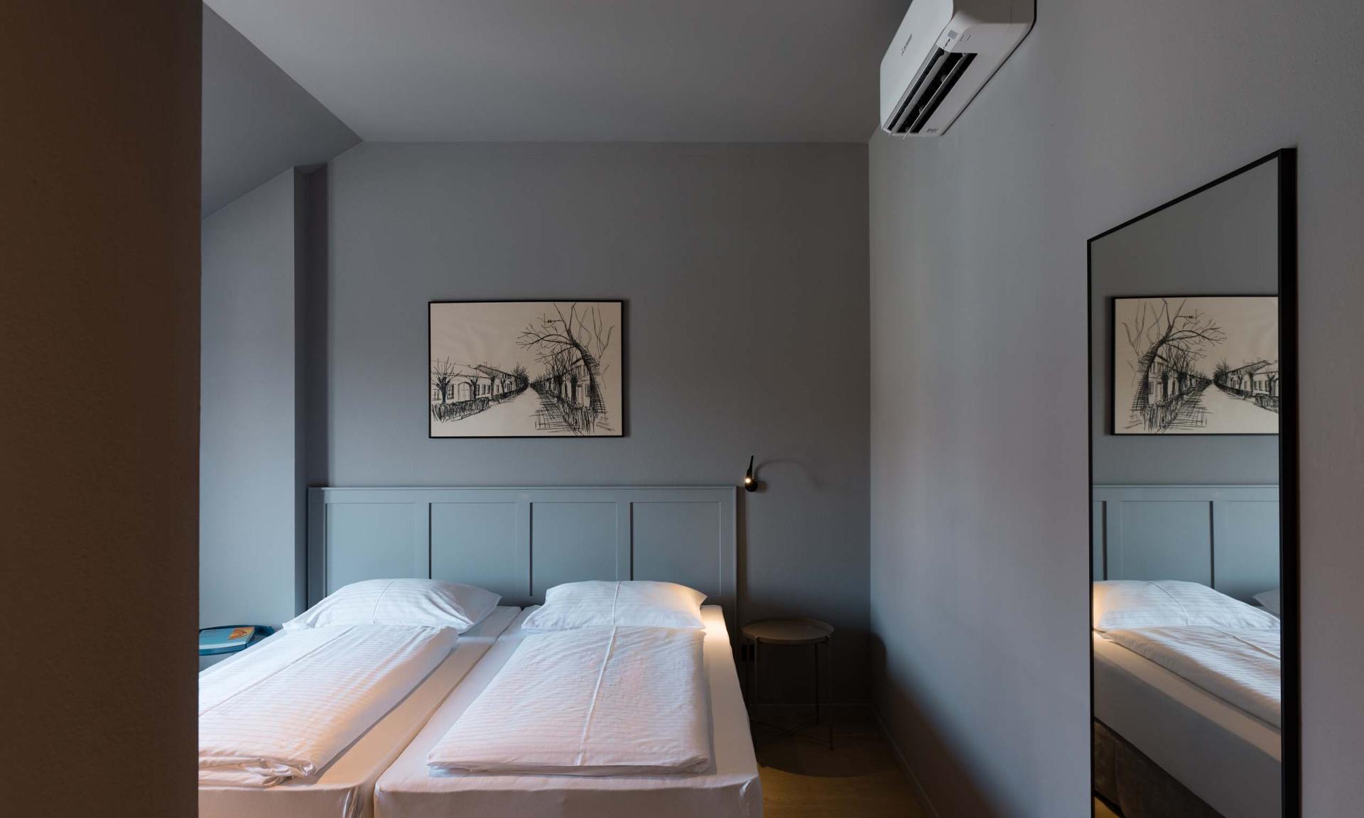 Schlafzimmer mit zwei Betten und Bild, Spiegel an der Wand, Luis v. Weyden