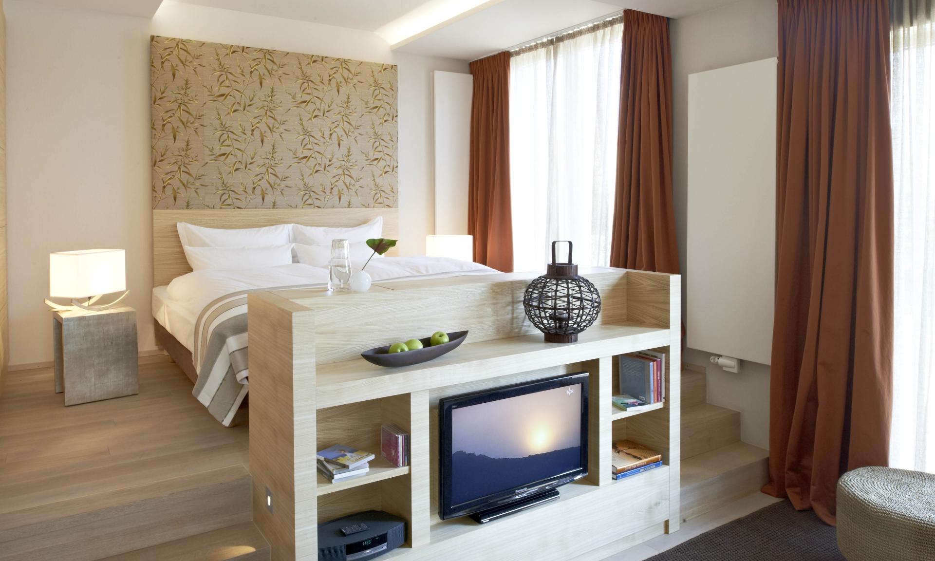 Modernes Hotelzimmer mit Lösch-Fernseher und warmen Vorhängen