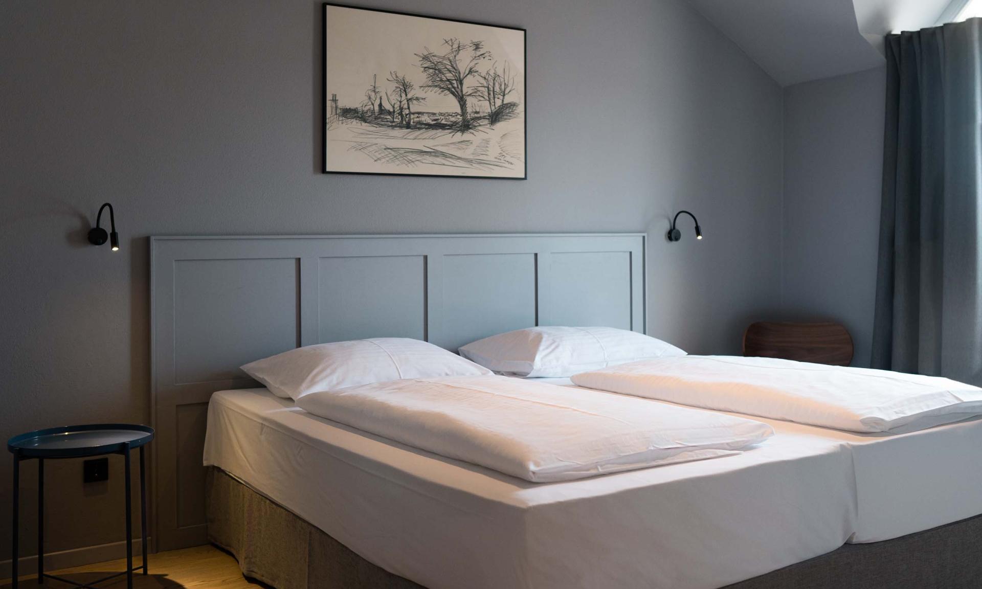 Schlichtes Schlafzimmer mit Doppelbett und Luis v. Weyden Kunst an der Wand