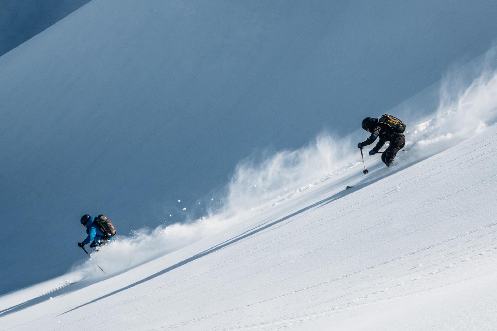 Zwei Skifahrer fahren am Hang mit Schnee bei Hotel Aurora