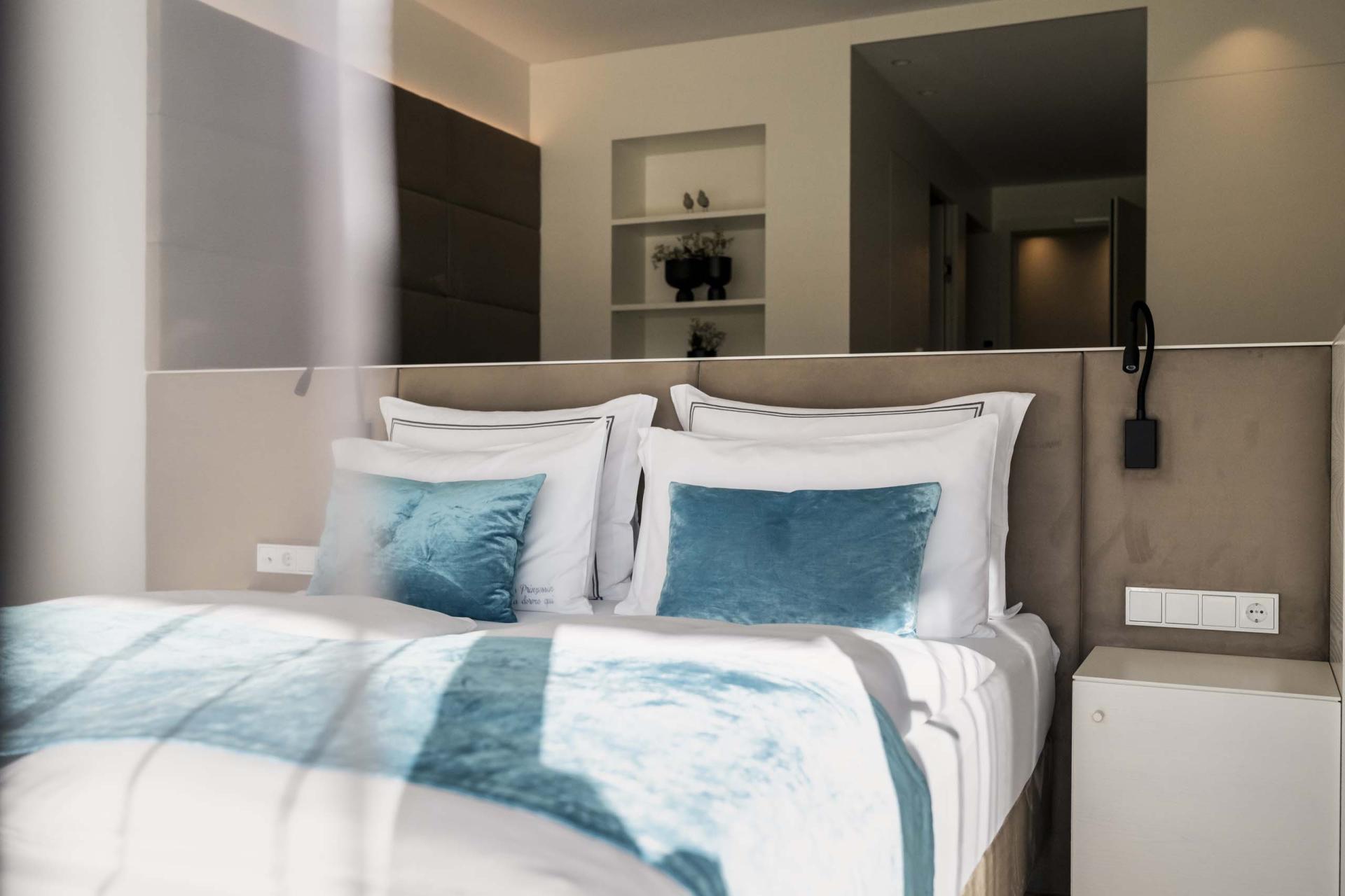 Modernes Schlafzimmer mit blauen Kissen im Hotel Monika