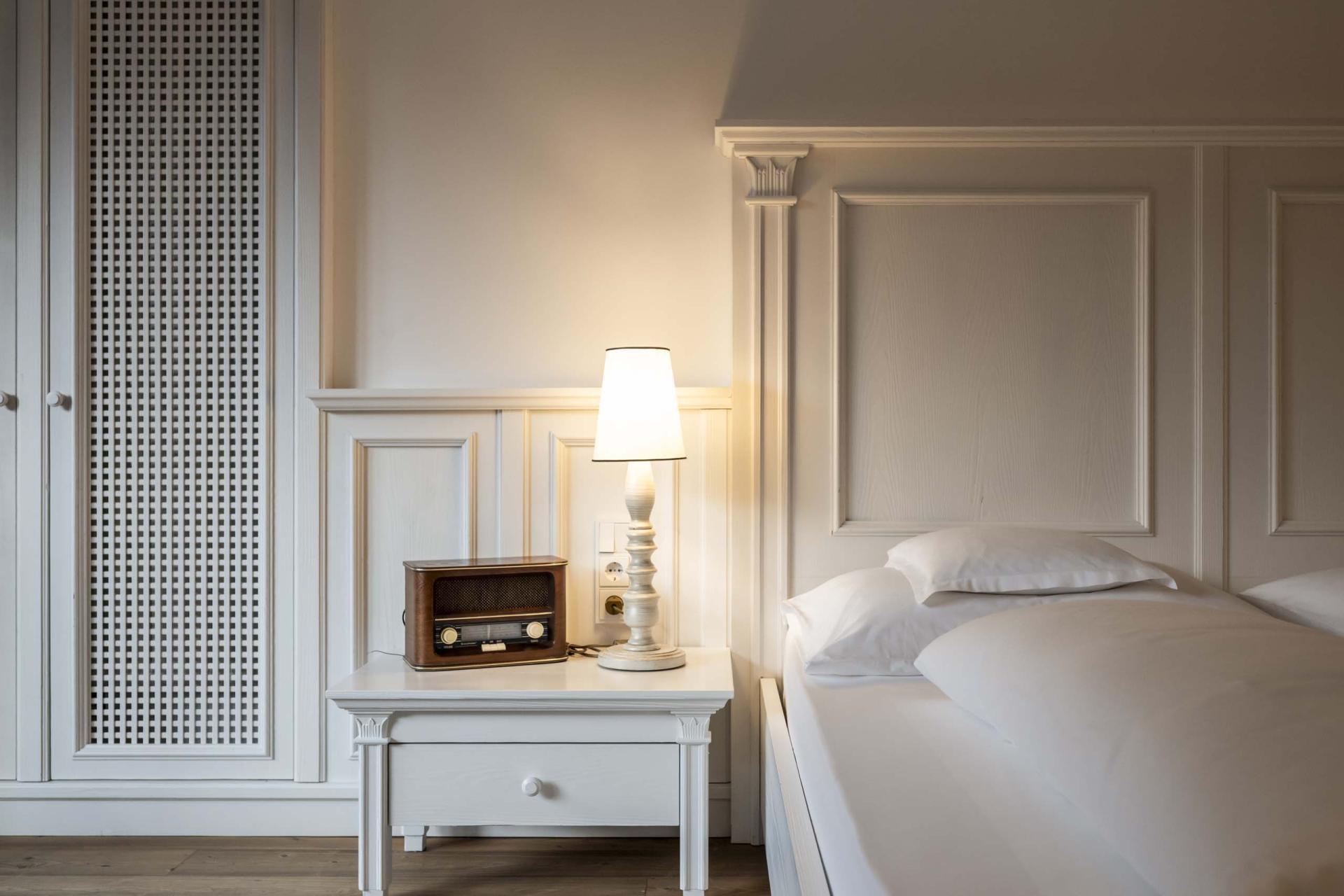 Schlafzimmer mit Bett und Nachttisch im Hotel Monika