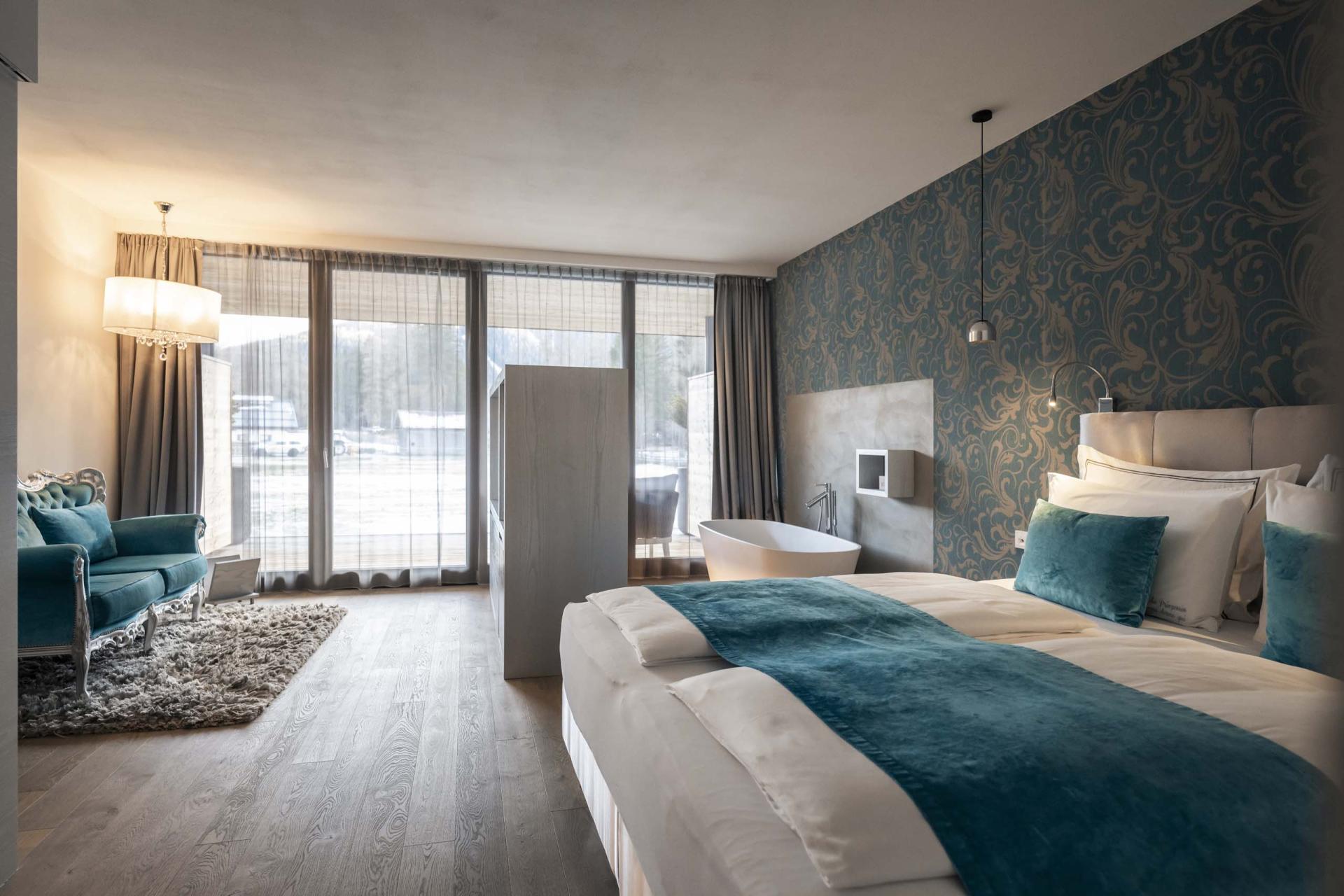 Modernes Hotelzimmer im Hotel Monika mit großer Fensterfront und Badewanne