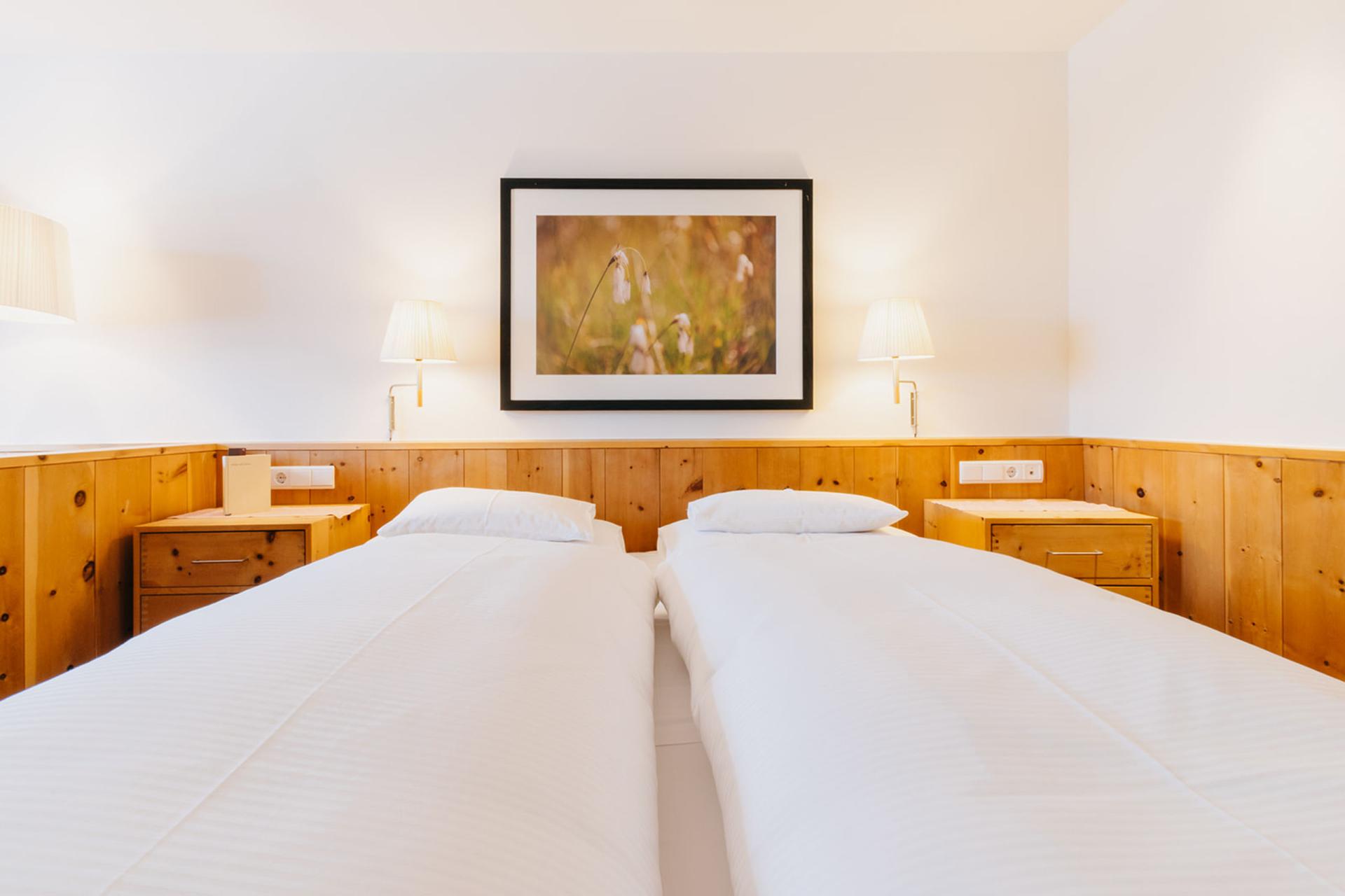 Hotel Aurora Zimmer mit zwei Einzelbetten und Holzverkleidung
