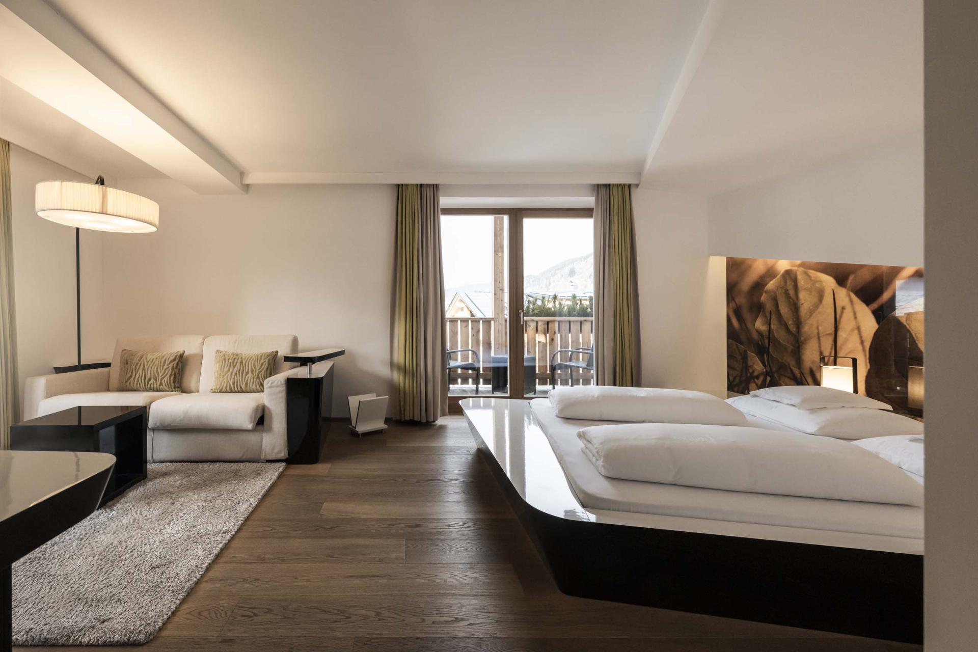 Modernes Hotelzimmer im Hotel Monika mit Bett und Sitzbereich