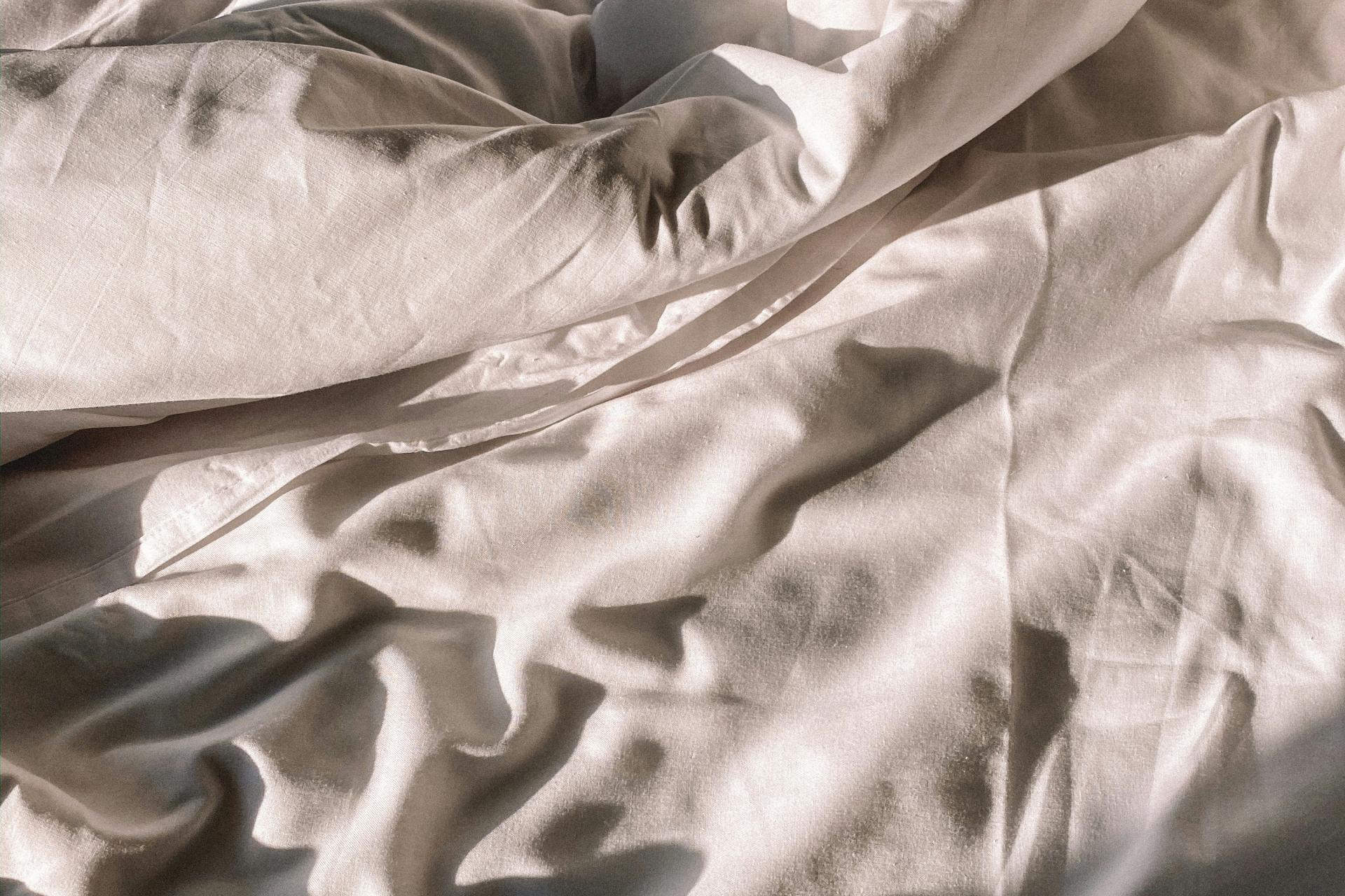 Verwobene weiße Bettwäsche im Hotel Aurora