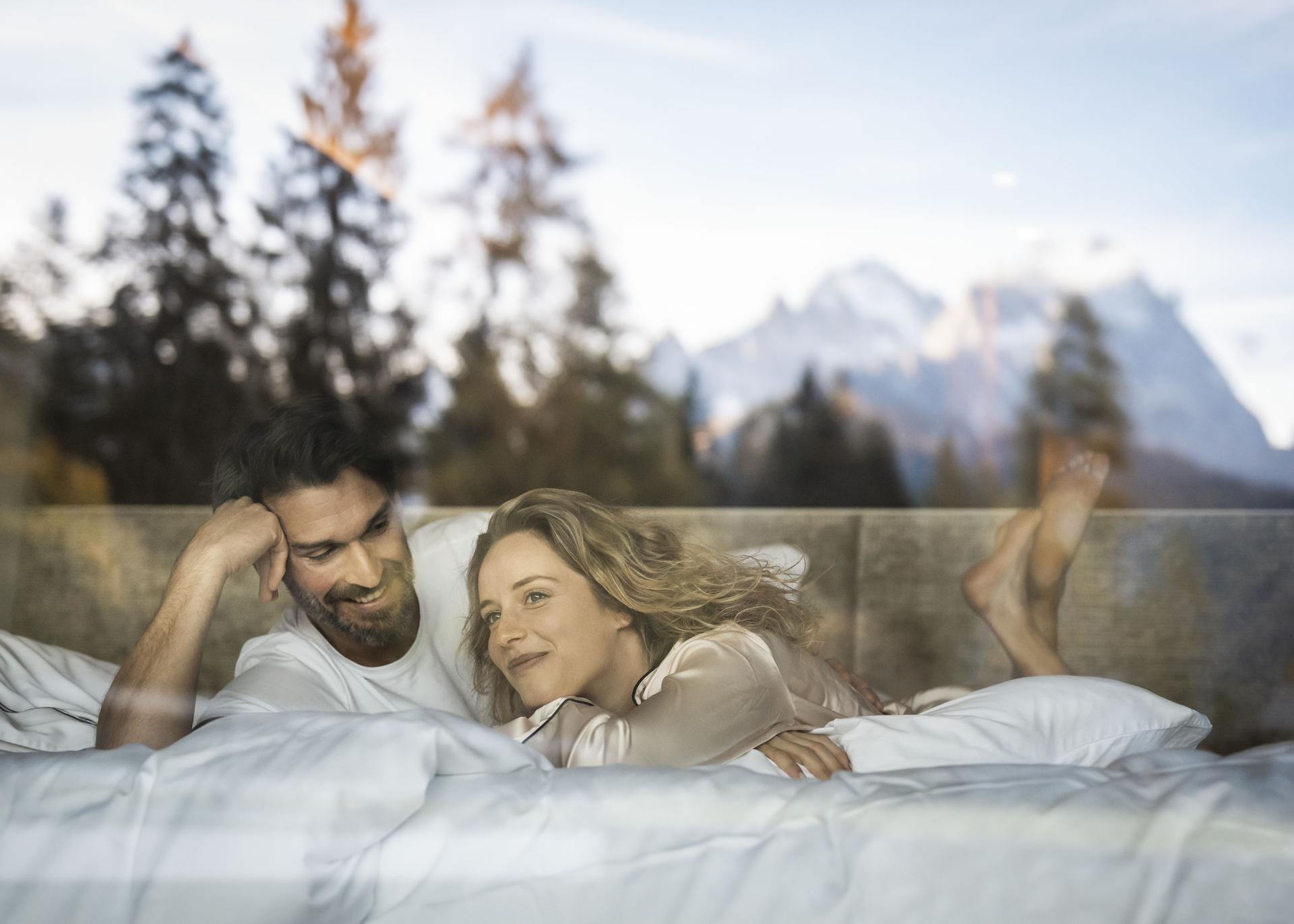 Entspannte Person auf Sofa mit Bergblick im Garten des Hotel Monika