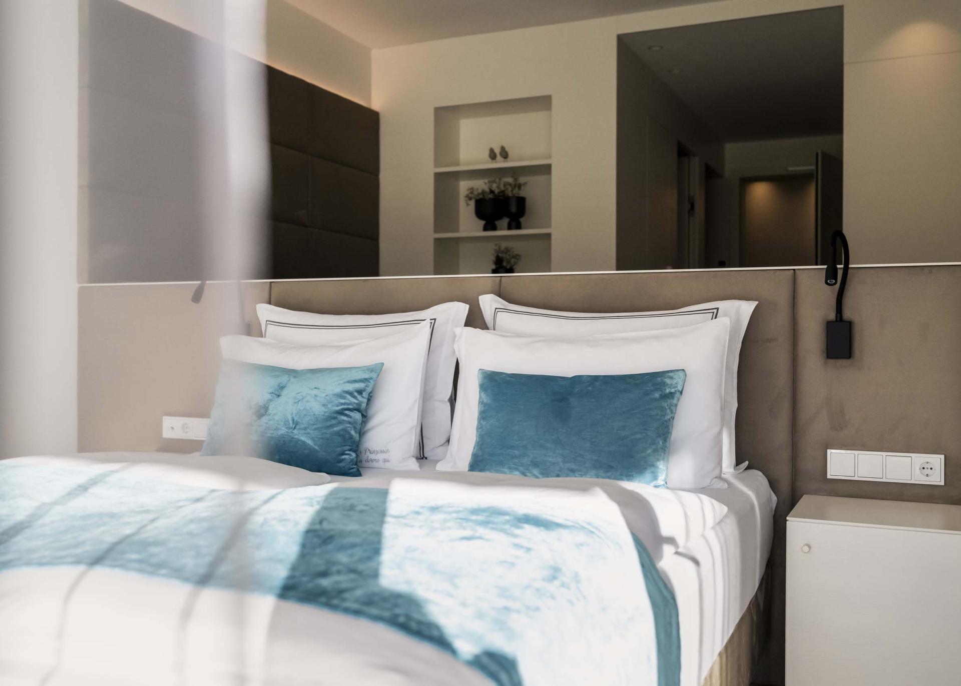 Modernes Schlafzimmer mit blauen Kissen im Hotel Monika