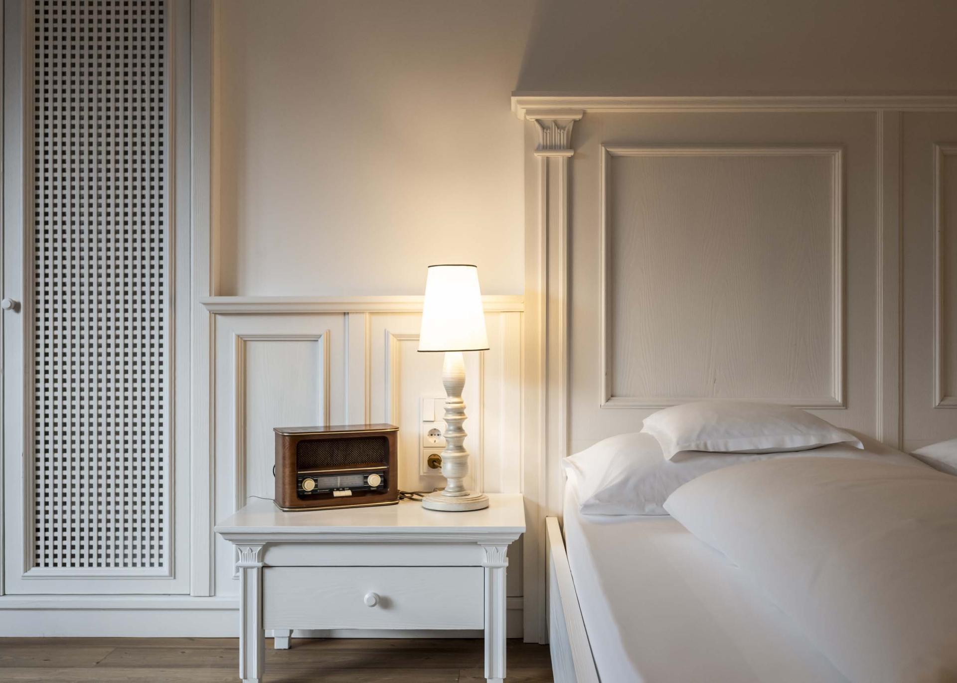 Schlafzimmer mit Bett und Nachttisch im Hotel Monika