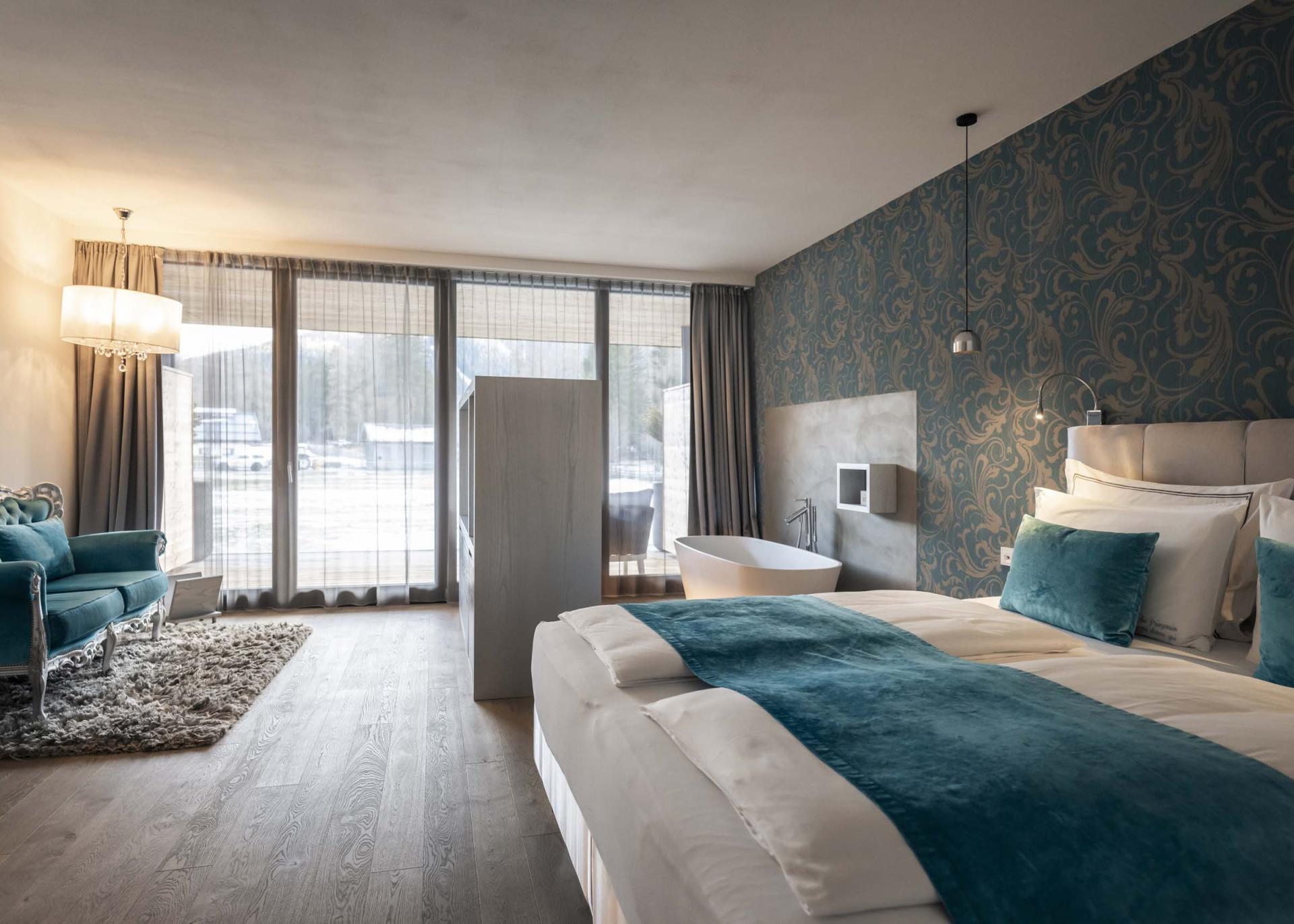 Modernes Hotelzimmer im Hotel Monika mit großer Fensterfront und Badewanne