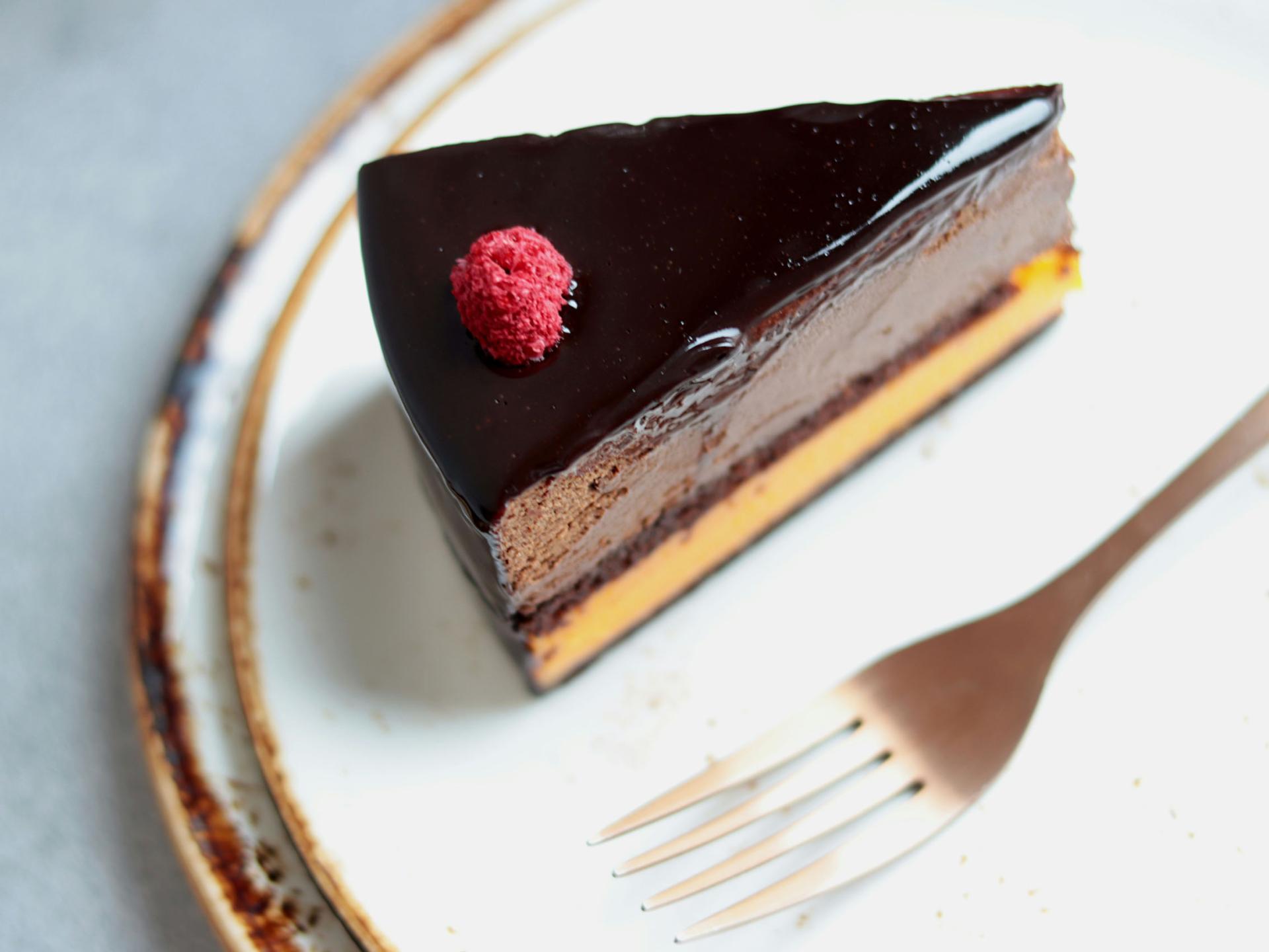 Schokoladenkuchenstück mit Himbeere auf Teller im Resort La Ginabelle Zermatt