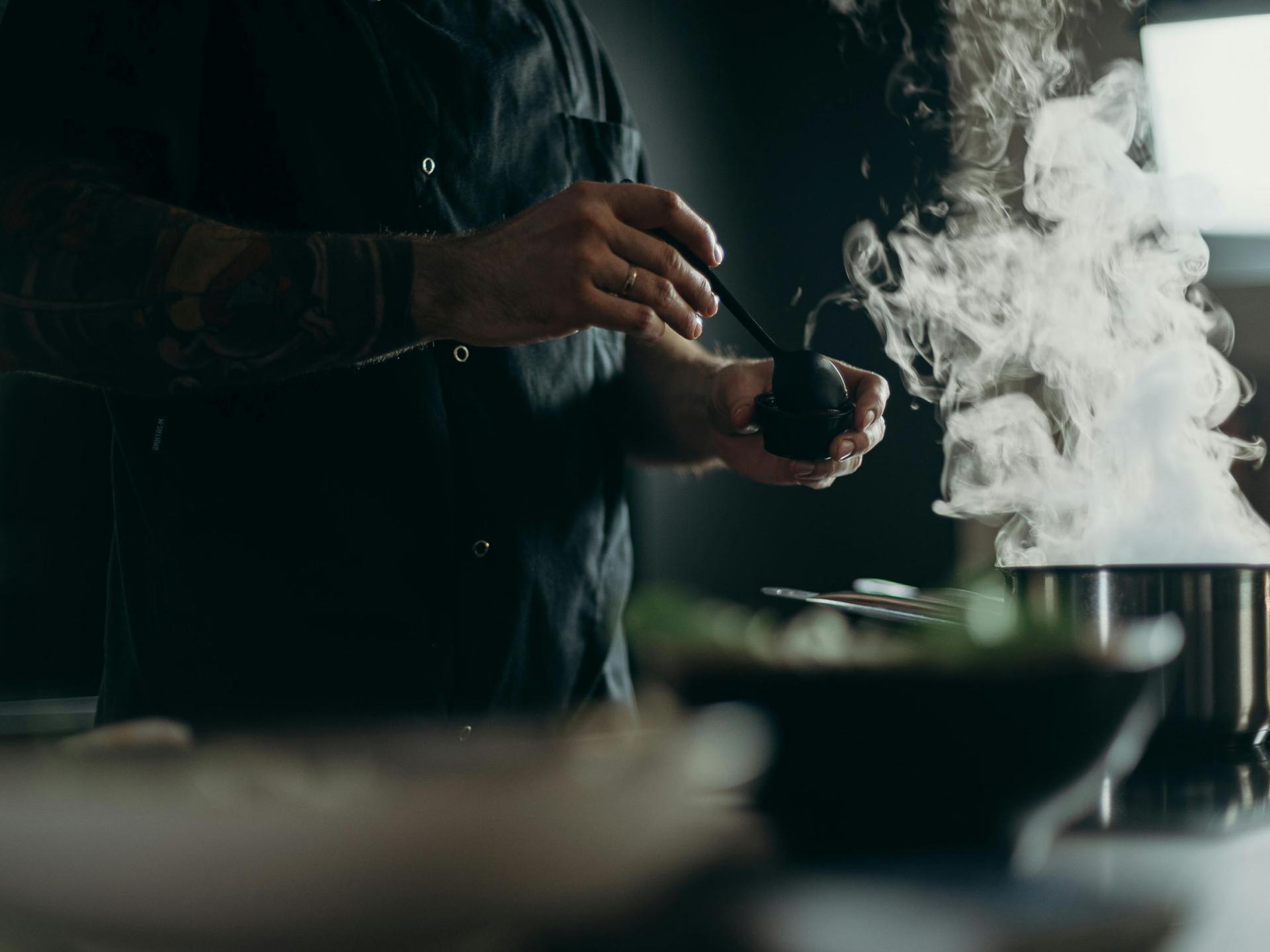 Koch bereitet dampfendes Gericht im Resort La Ginabelle Zermatt zu