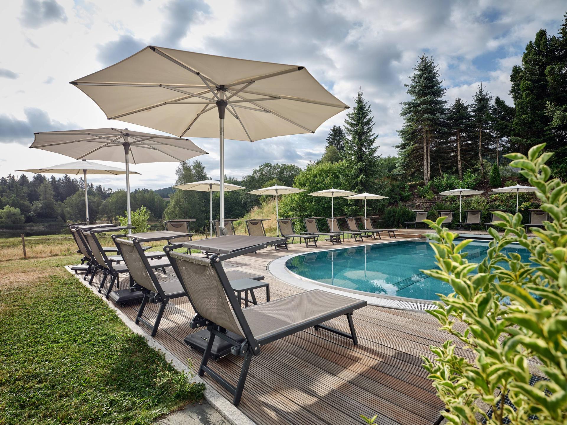 Pool mit Liegen und Sonnenschirmen im Hotel Reppert