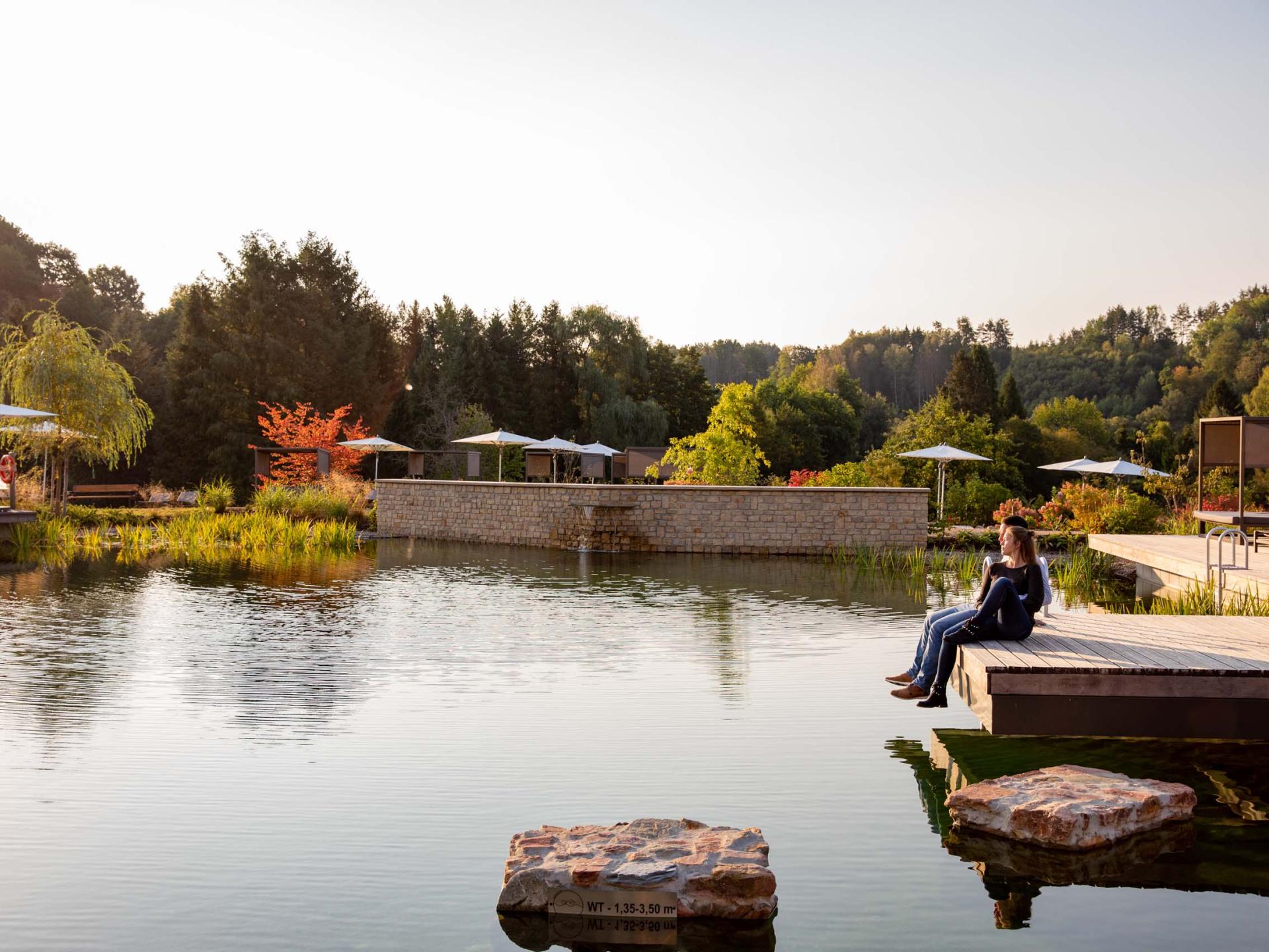 Pfälzblick Wald Spa Resort mit Teich und entspannter Sitzenden in der Natur