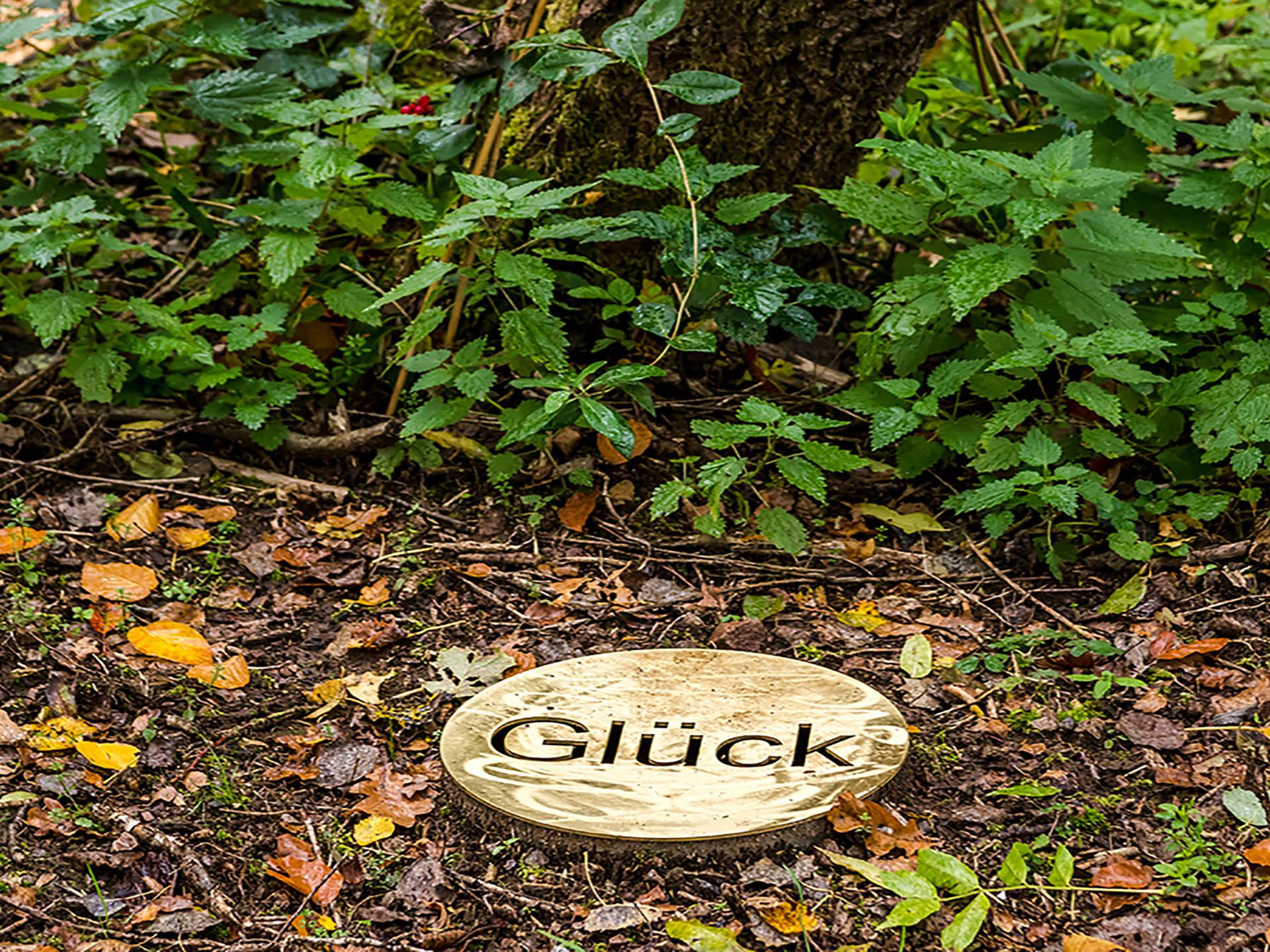 Messingtaler mit der Aufschrift "Glück" im Meditationsbereich zeit raum bei der Seezeitlodge