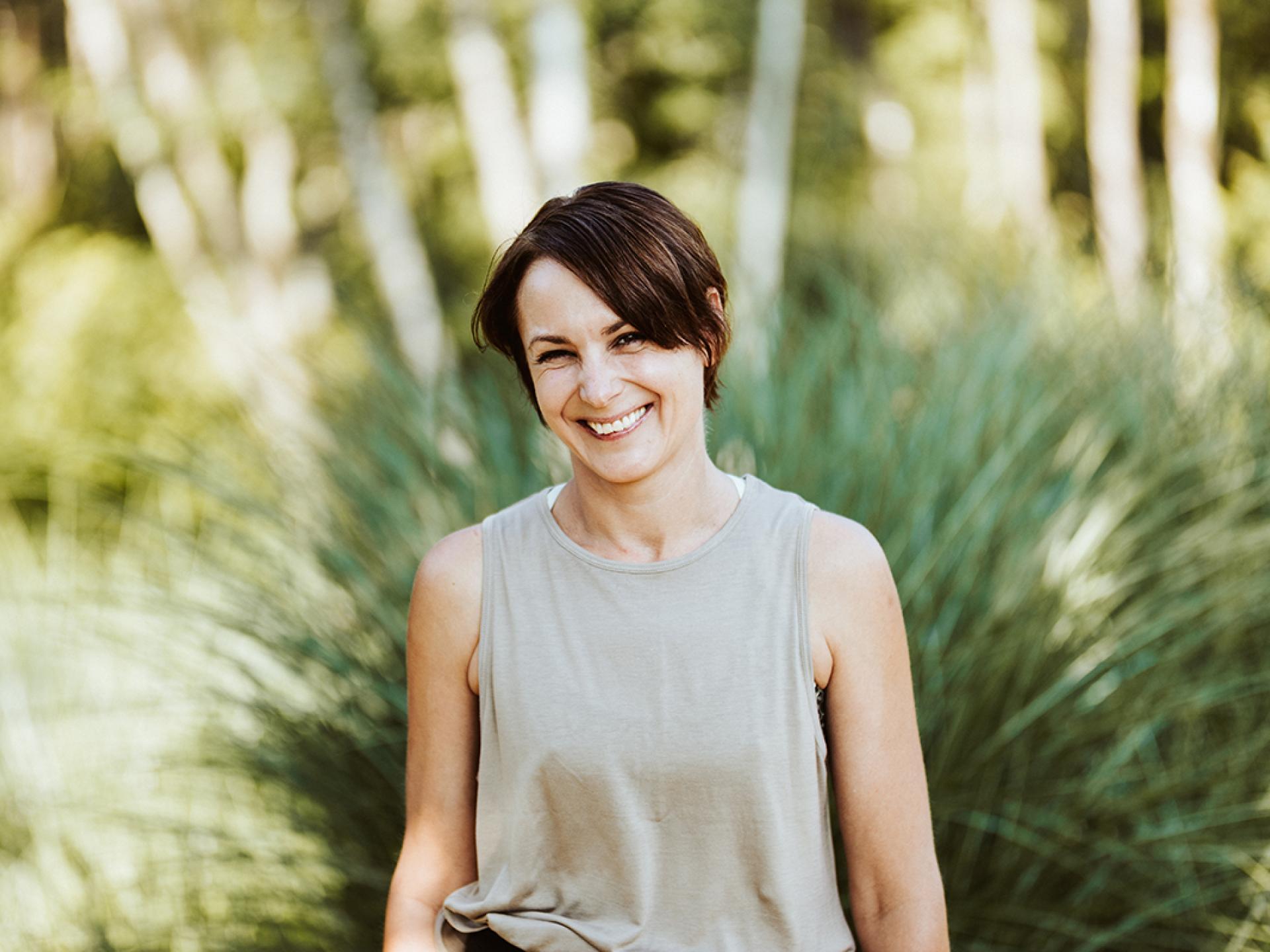 Smiling woman in a green setting – Seezeitlodge Hotel & Spa