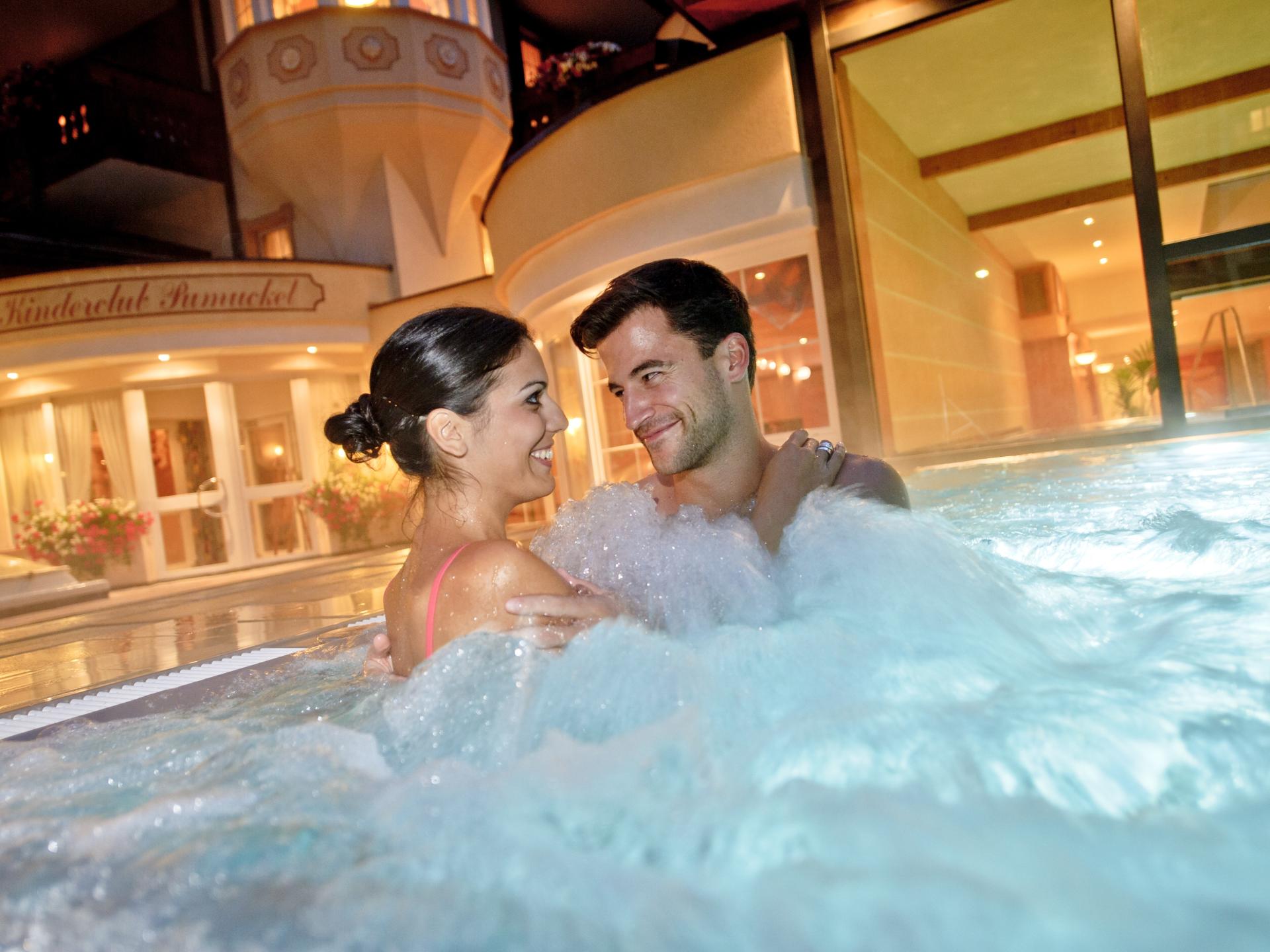 Couple dans jacuzzi au Resort La Ginabelle Zermatt sous éclairage du soir
