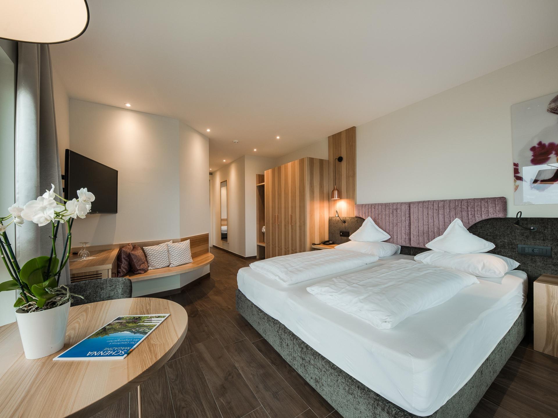 Modernes Schlafzimmer im Alpenpalais Kröll mit Doppelbett und Sitzecke