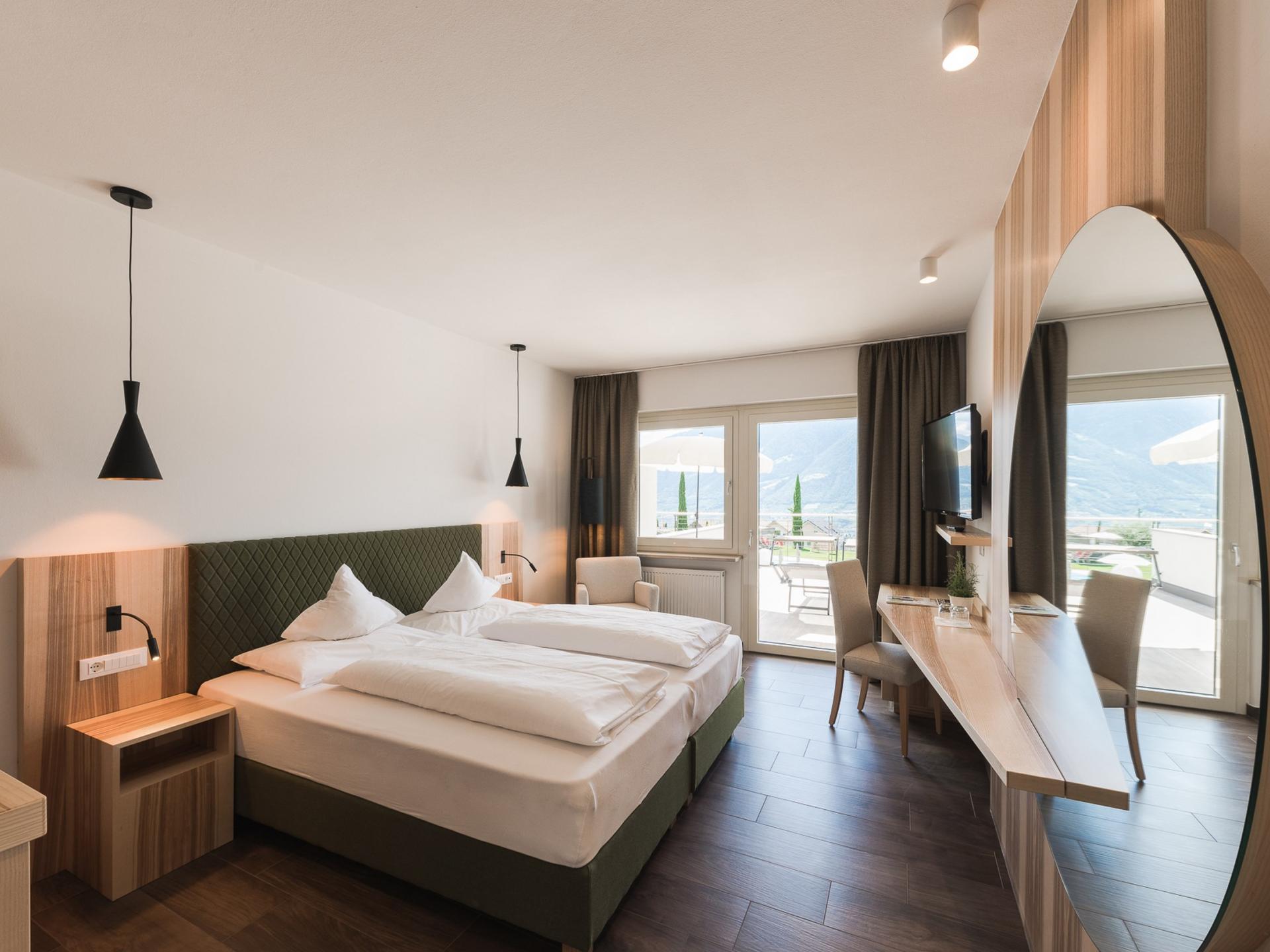 Modernes Schlafzimmer im Alpenpalais Kröll mit Balkon und Bergblick