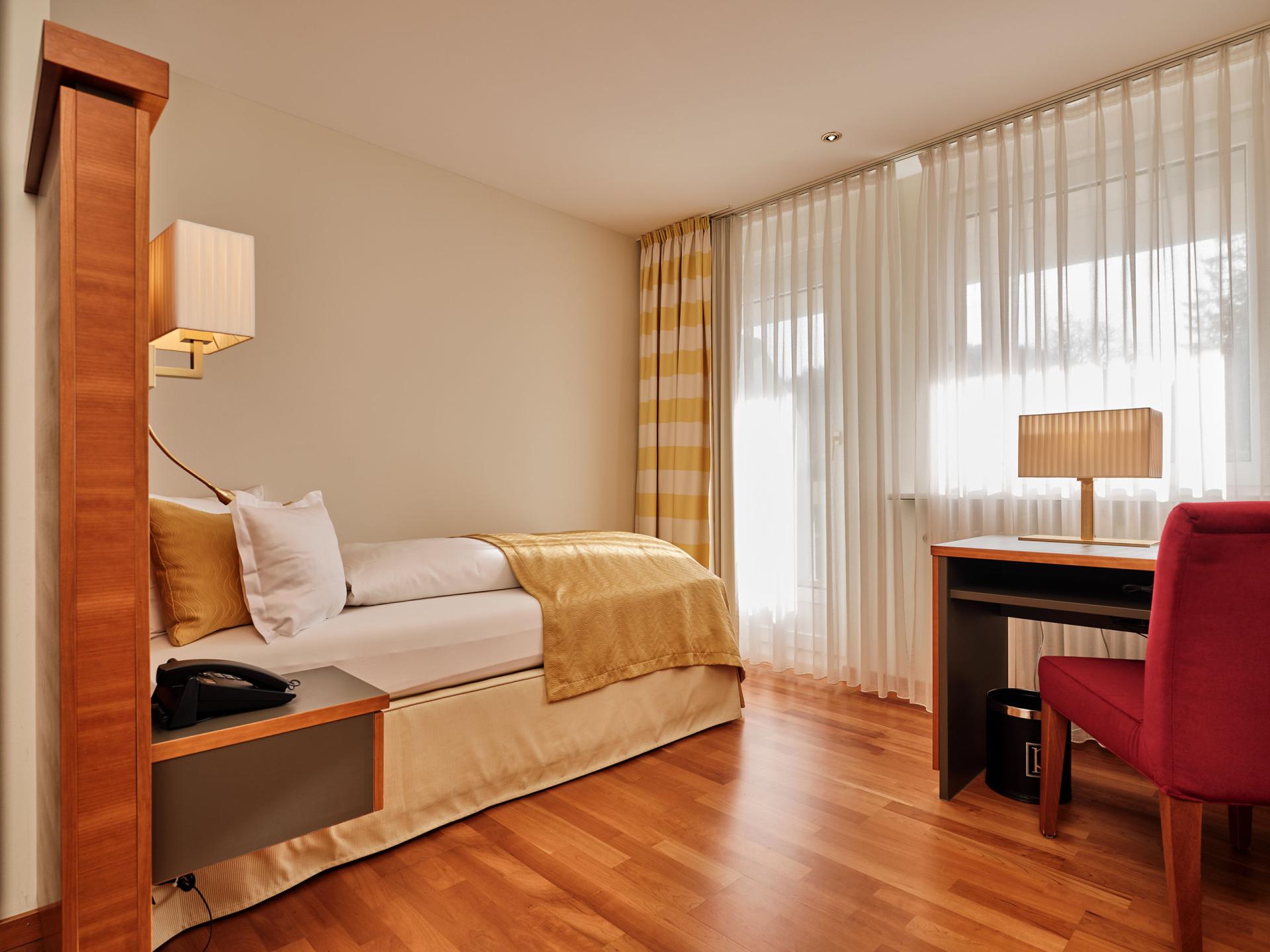 Modernes Einzelzimmer im Hotel Reppert mit Holzfußboden und warmem Licht