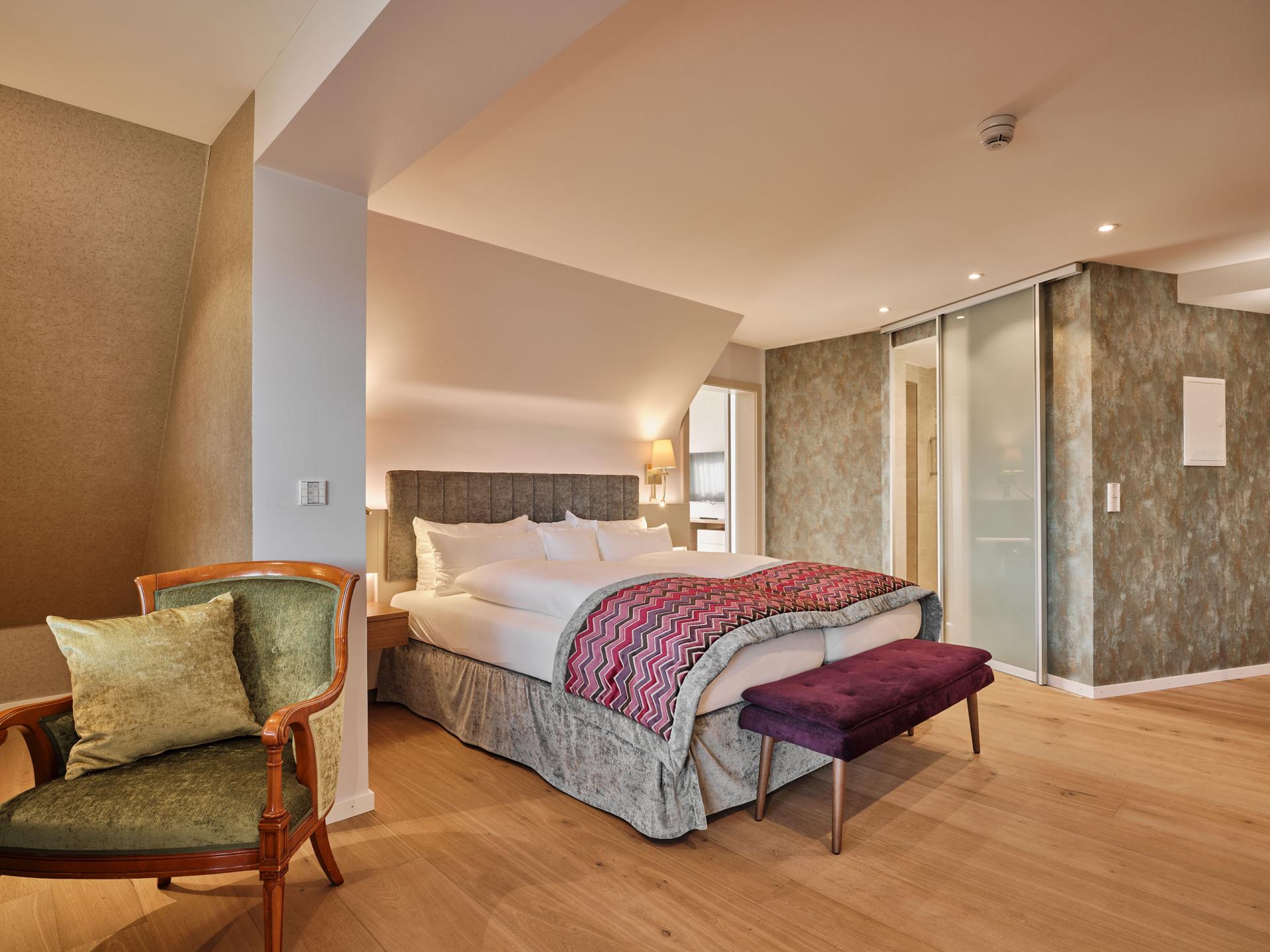 Modernes Schlafzimmer im Hotel Reppert mit Doppelbett und gemütlichem Sessel