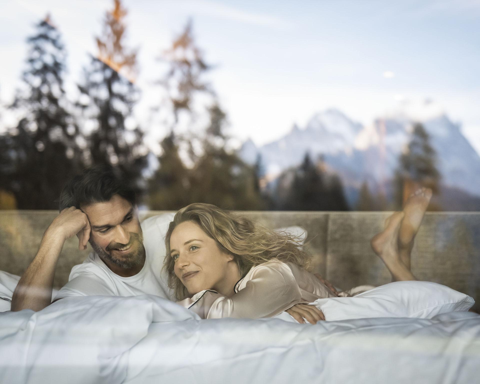 Entspannte Person auf Sofa mit Bergblick im Garten des Hotel Monika