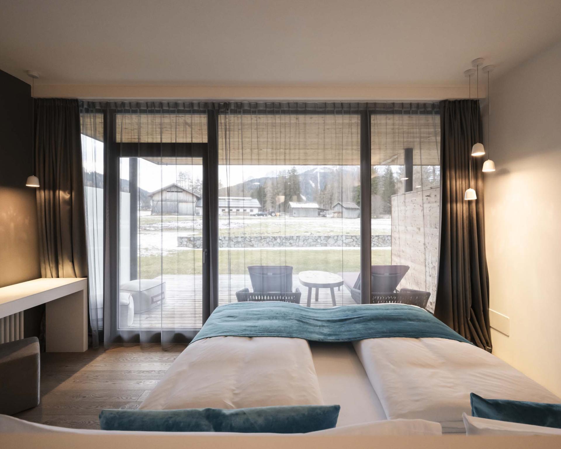Hotel Monika Zimmer mit Doppelbett und Blick auf Terrasse und Berge
