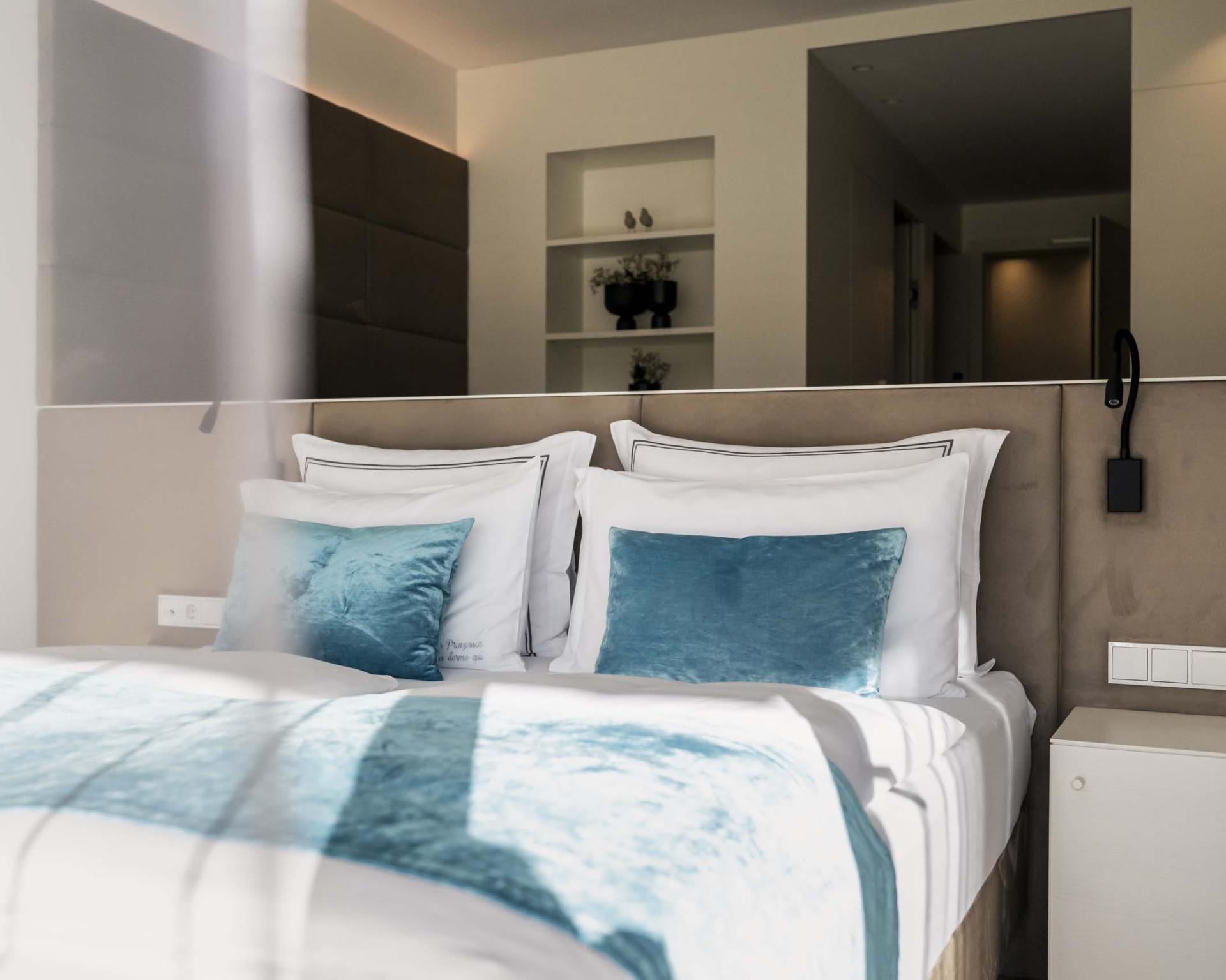 Modernes Schlafzimmer mit blauen Kissen im Hotel Monika