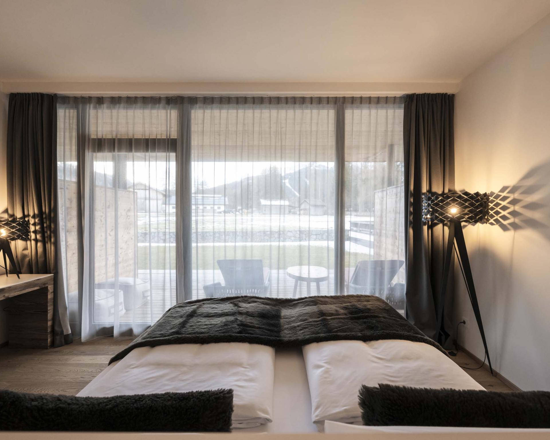 Zimmeransicht im Hotel Monika mit Bett, Vorhängen und Terrasse