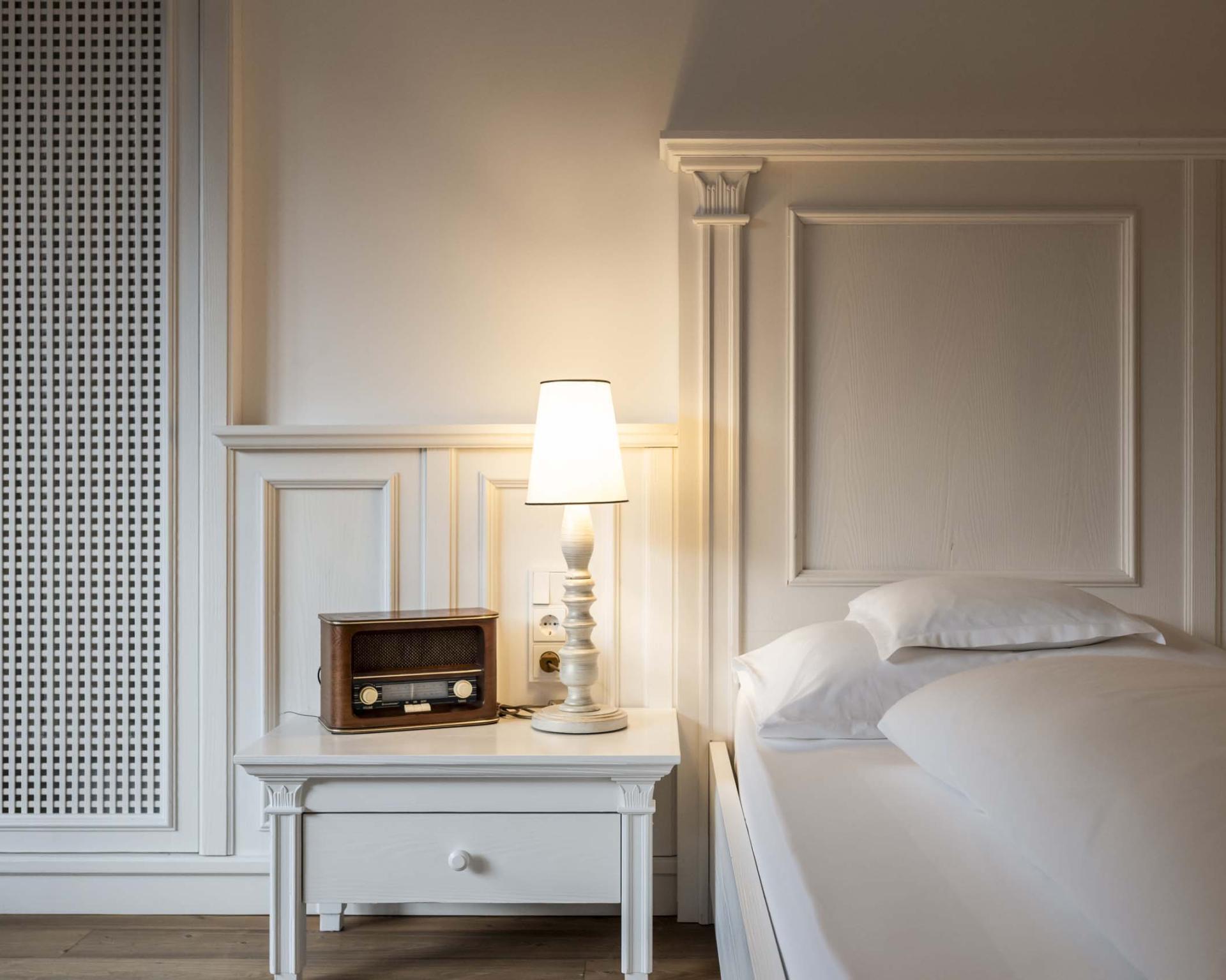 Schlafzimmer mit Bett und Nachttisch im Hotel Monika