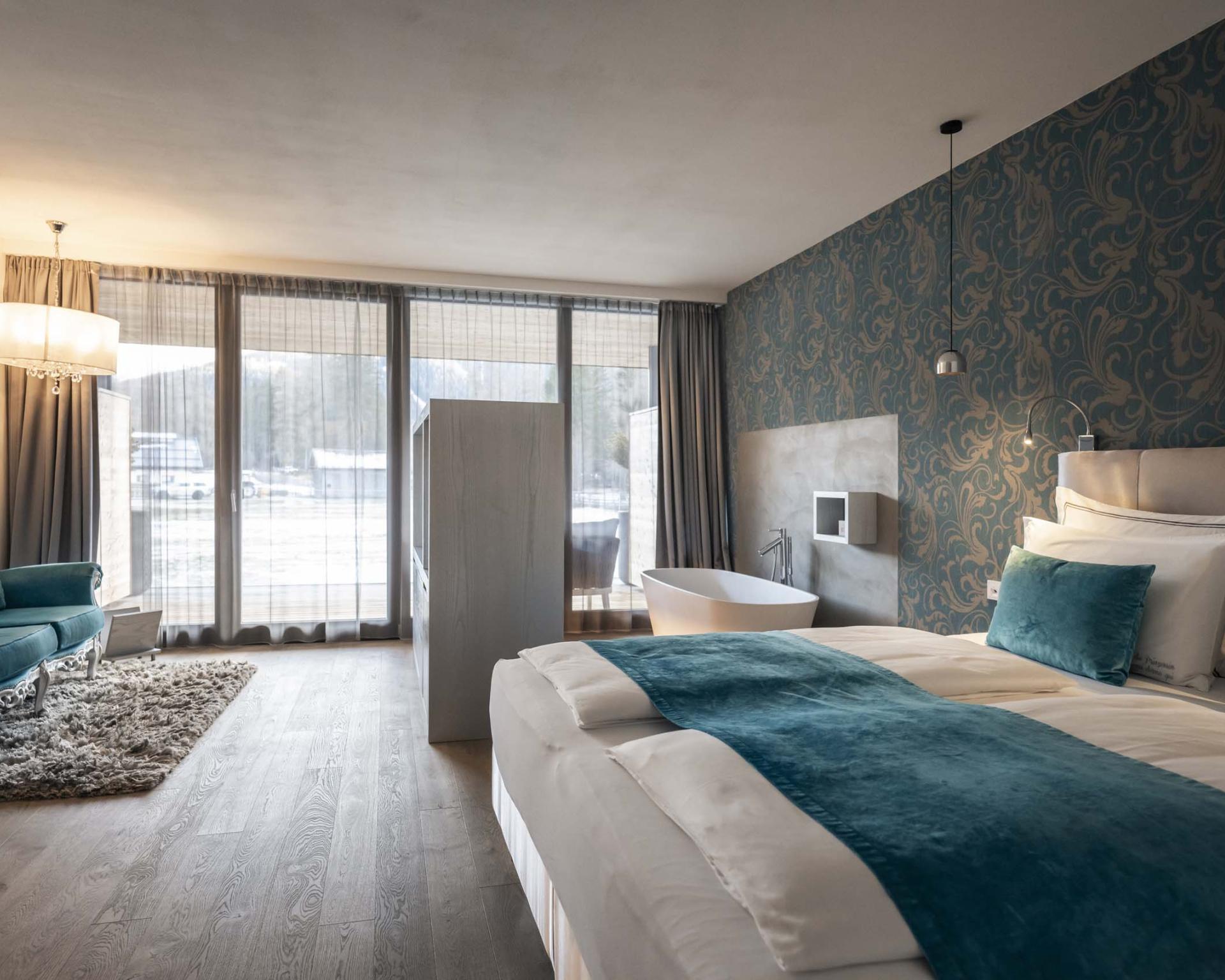 Modernes Hotelzimmer im Hotel Monika mit großer Fensterfront und Badewanne