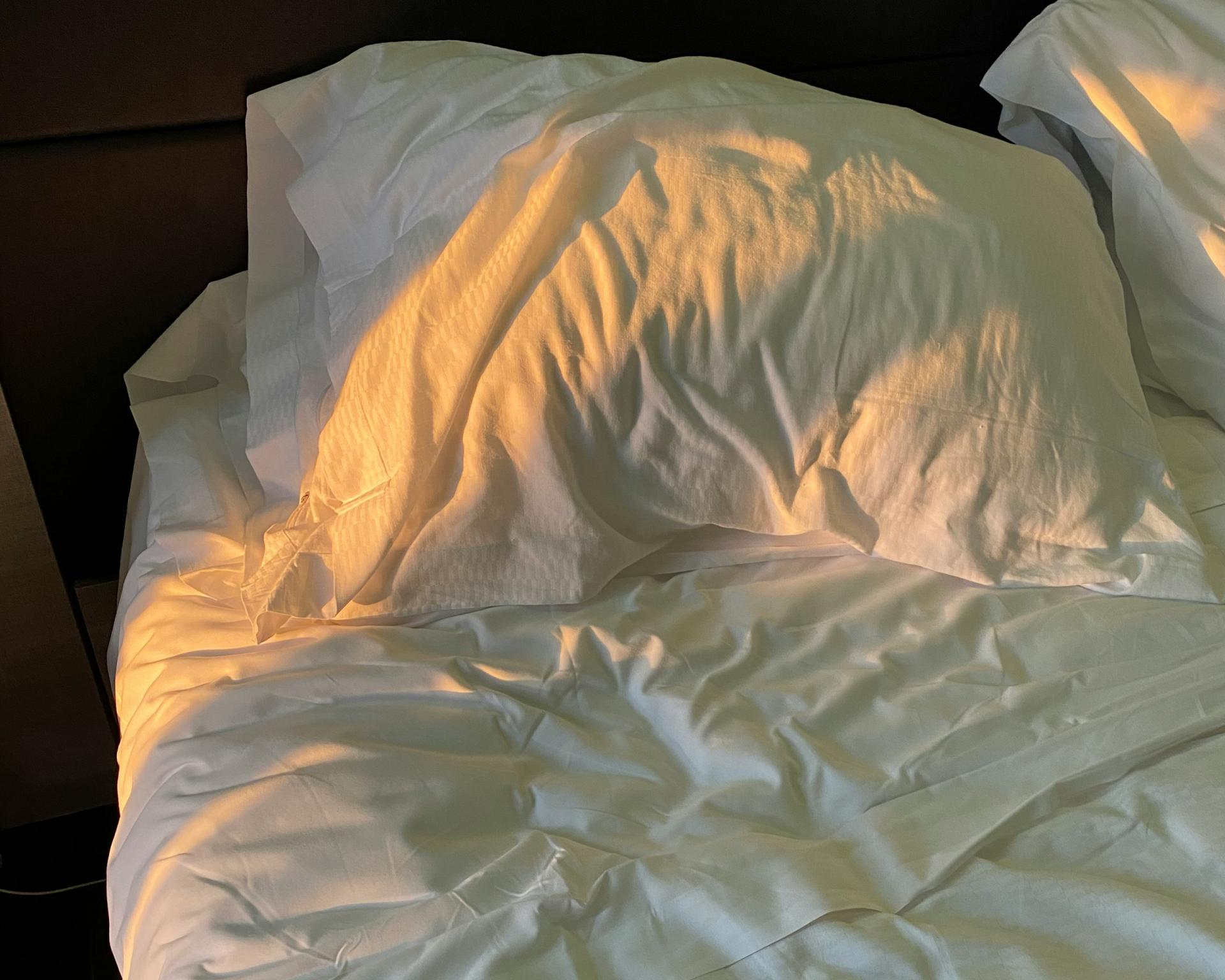 Weißes Kopfkissen und Bettwäsche auf einem Bett im Glockna Hotelzimmer