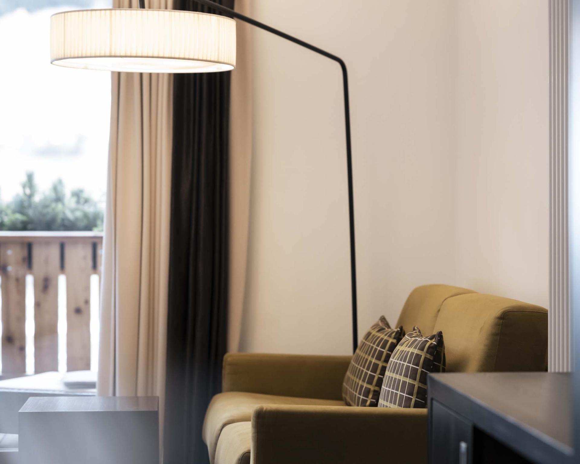 Gemütliche Sitzecke im Hotel Monika mit Sofa und Stehlampe