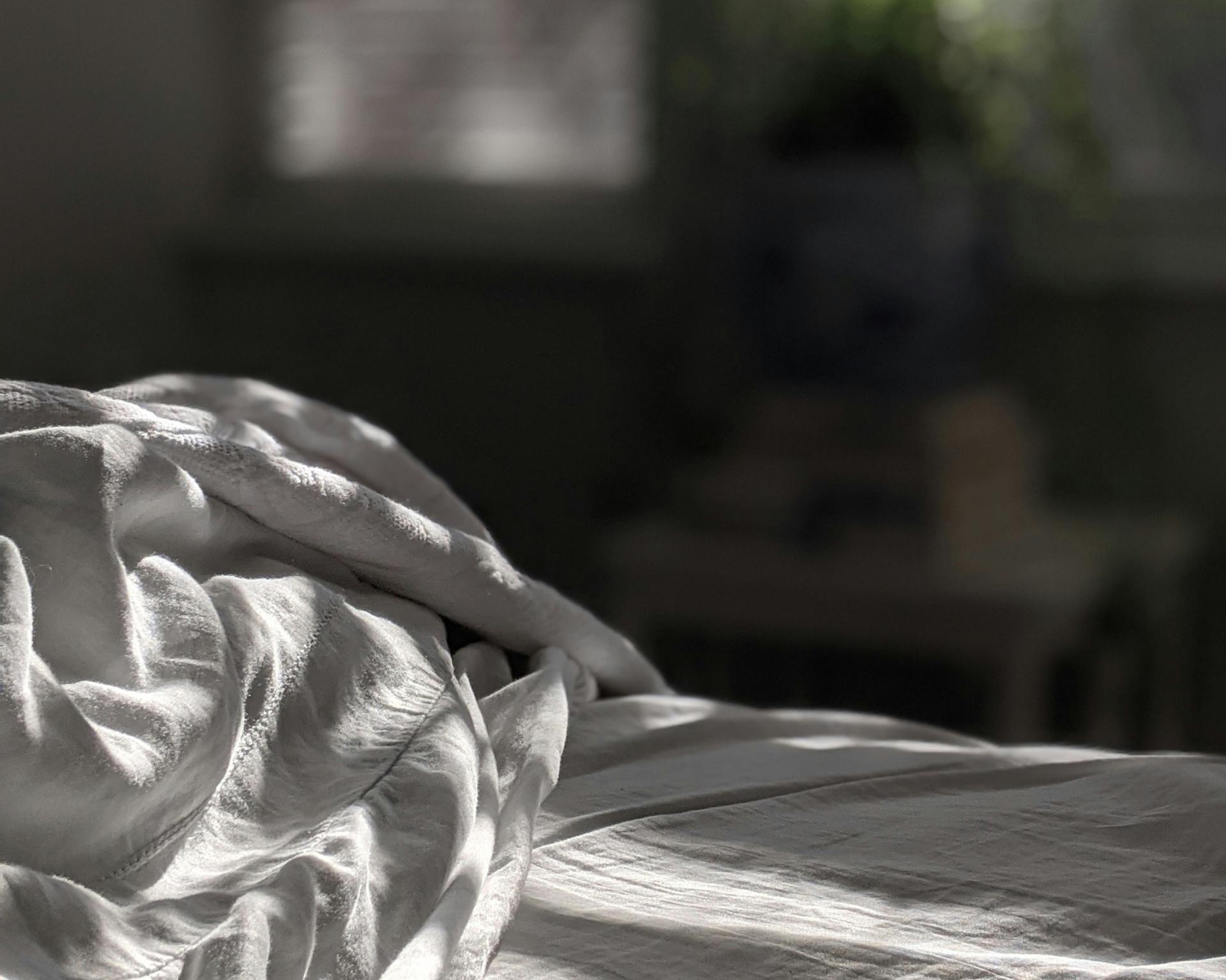 Soft wrinkled bed sheet in sunlight in a Glockna room