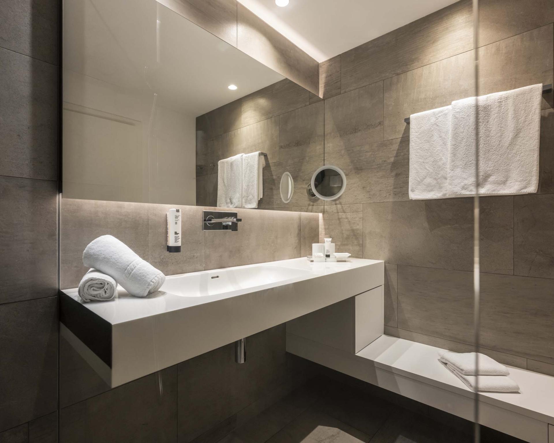 Modernes Badezimmer im Hotel Monika mit Waschbecken und Handtüchern