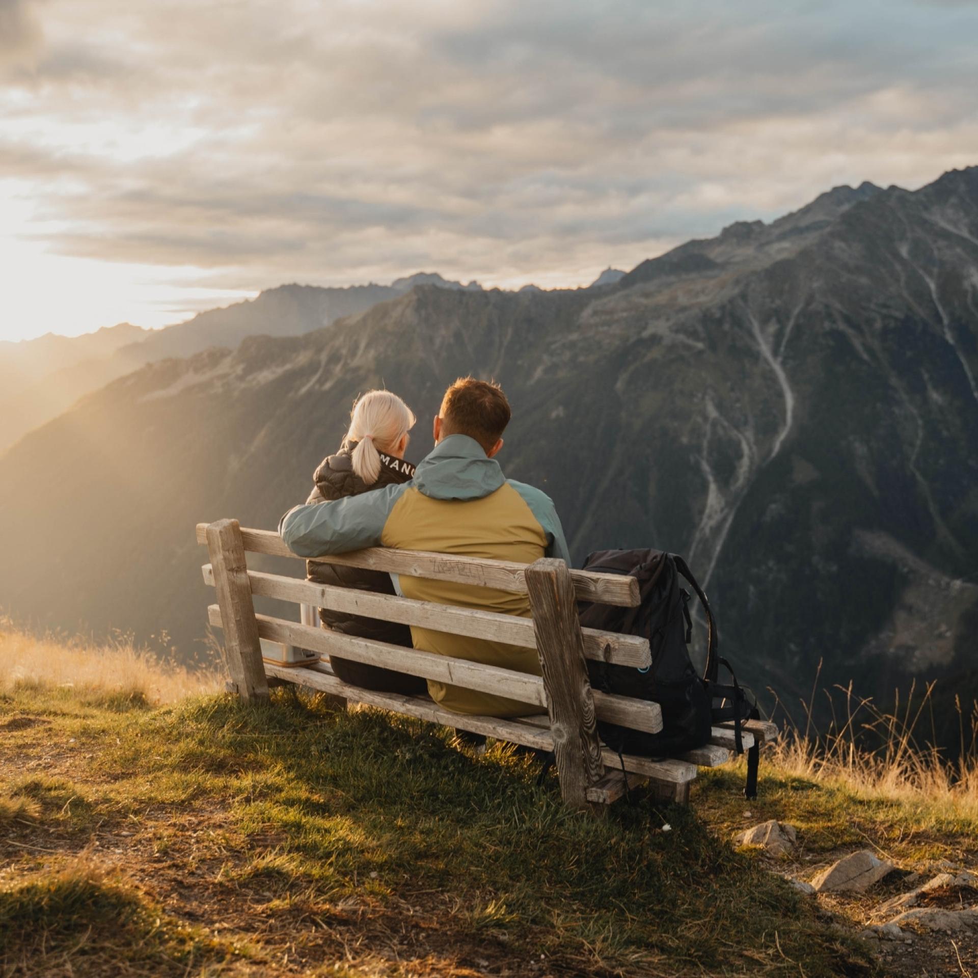 Paar auf Bank mit Bergblick bei Sonnenuntergang nahe Hotel Gassner **** Superior