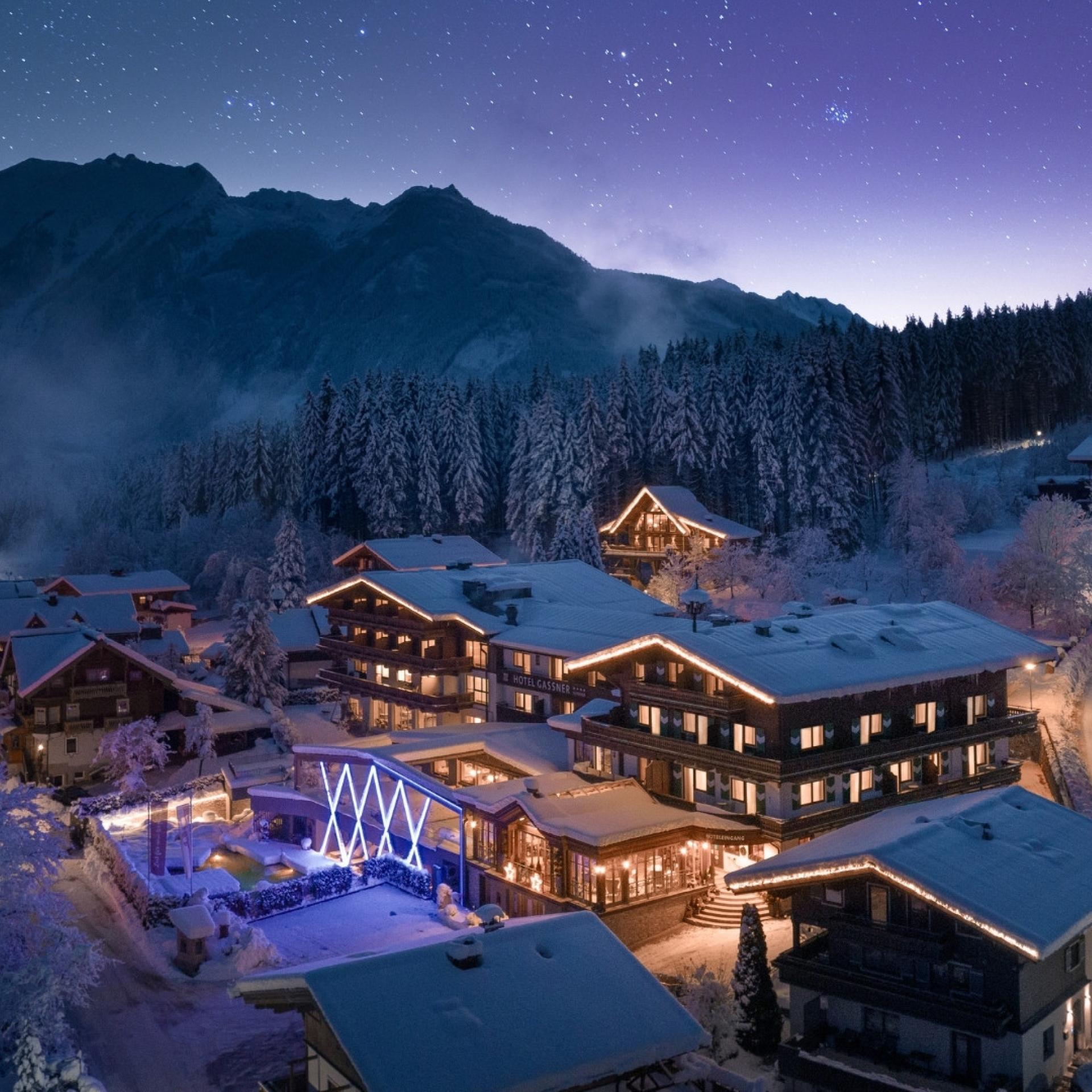 Hotel Gassner mit dem Baumhaus im Hintergrund bei sternenklarer Nacht in der Vorweihnachtszeit