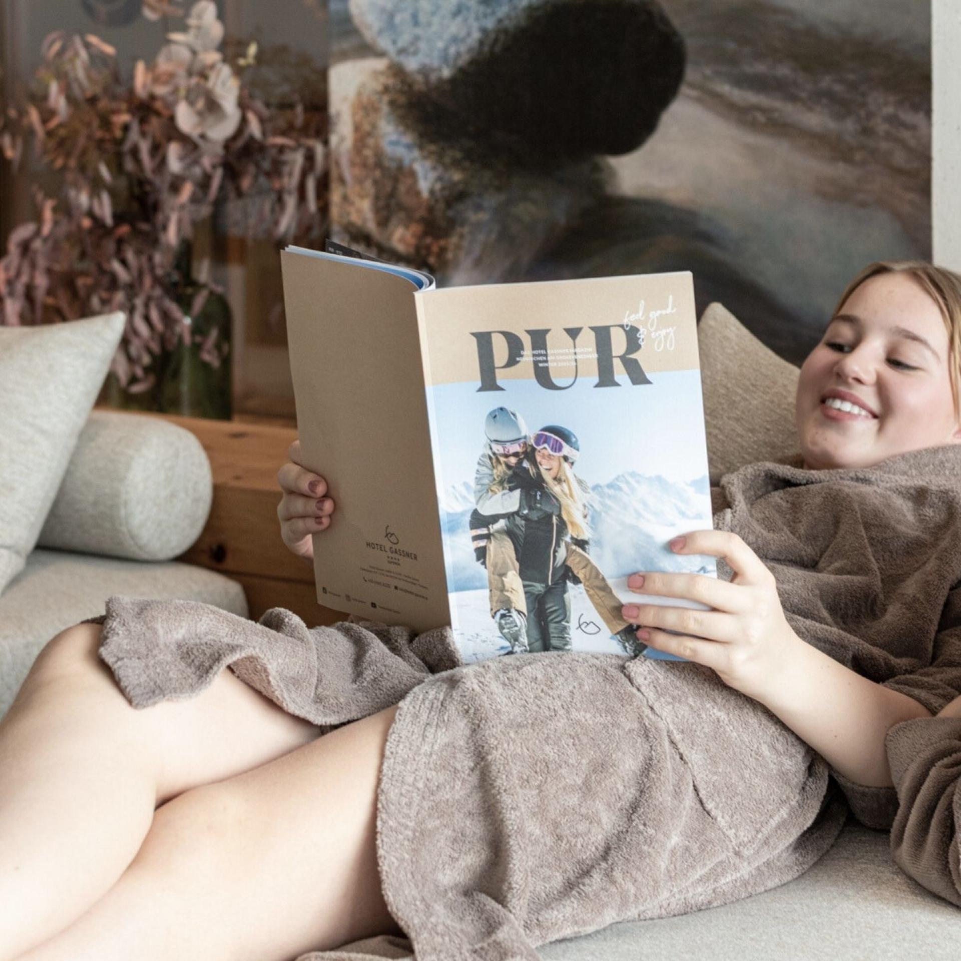 Drei Kinder relaxen im Familienruheraum vom Hotel Gassner und blättern durch das Wintermagazin