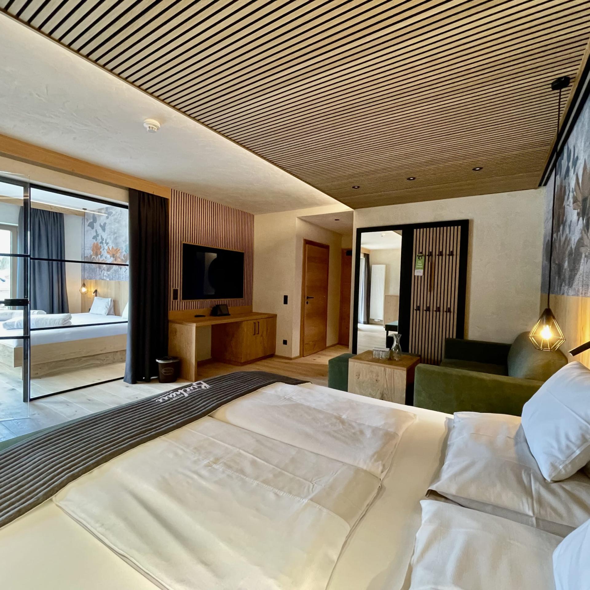 Modern eingerichtetes Zimmer im Familienresort Buchau mit Bett und Sitzbereich