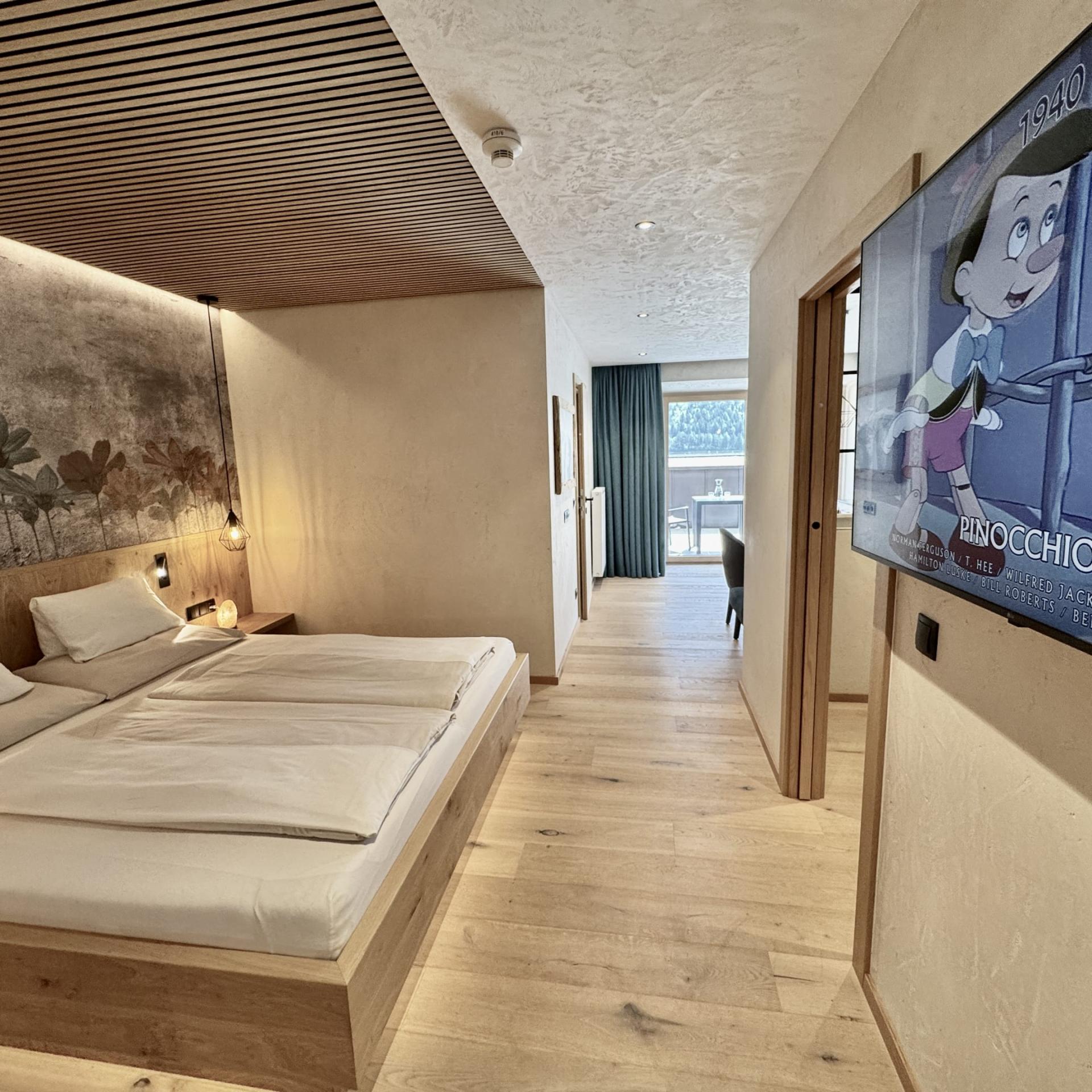 Modernes Schlafzimmer im Familienresort Buchau mit Fernseher und Holzboden