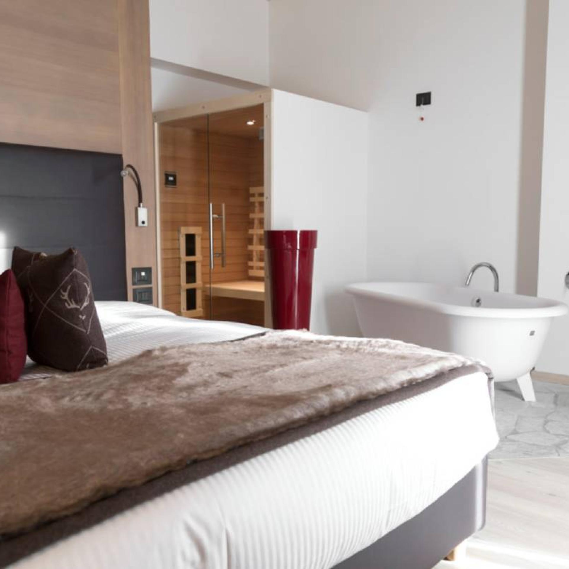 Camera moderna all'Hotel San Giacomo con letto, vasca da bagno e sauna