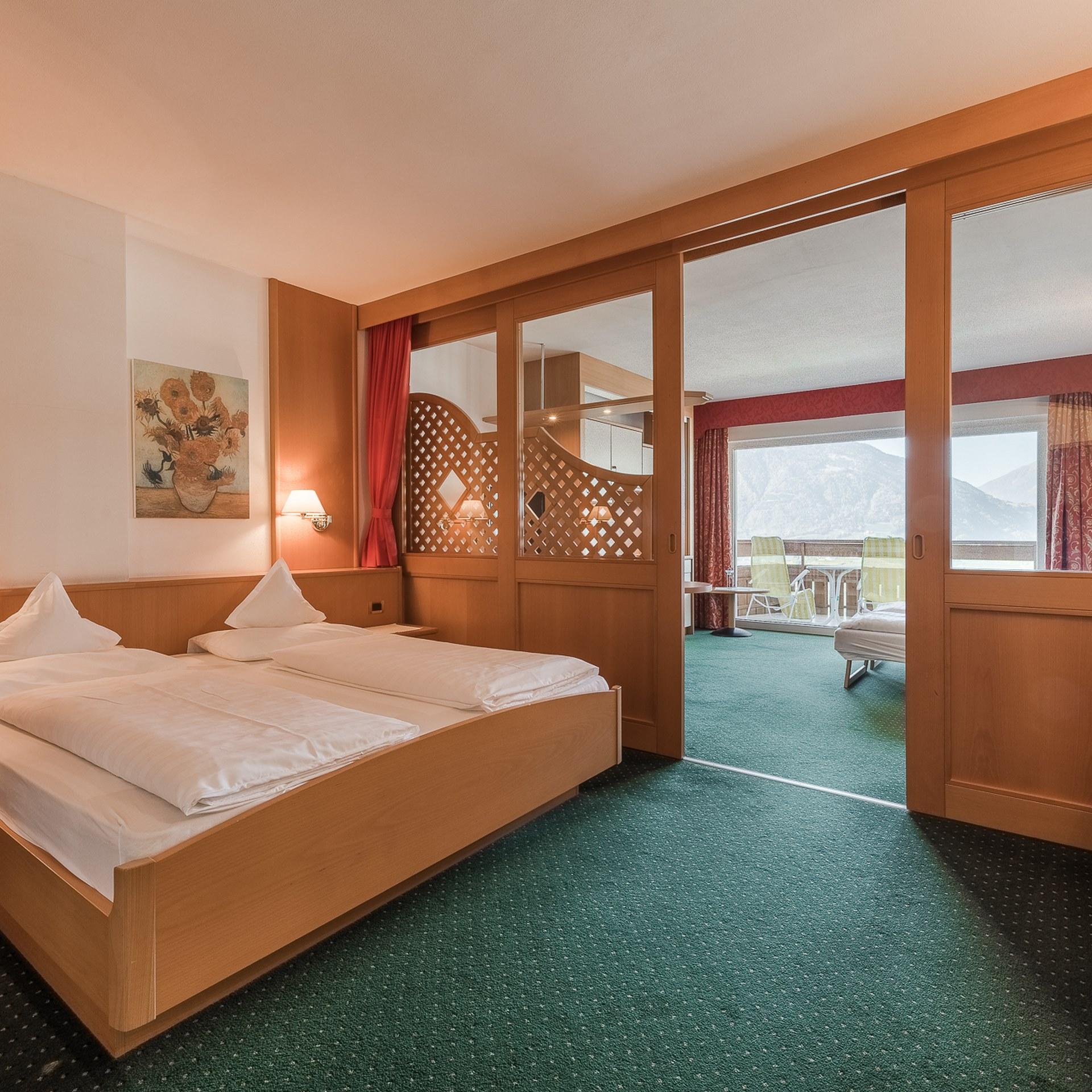 Gemütliches Zimmer im Alpenpalais Kröll mit Doppelbett und Balkon