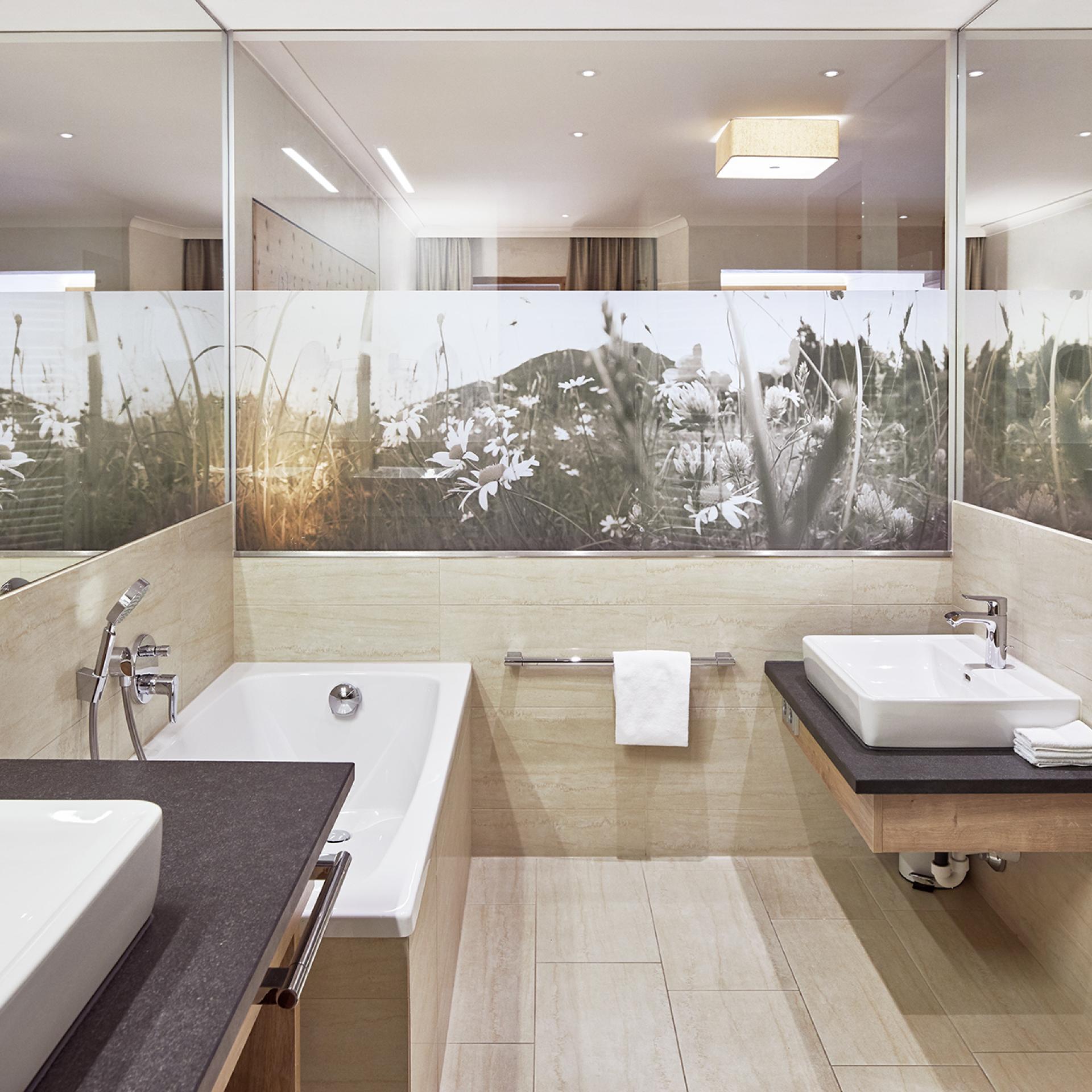 Modern bathroom at Familienresort Buchau with bathtub and double sinks