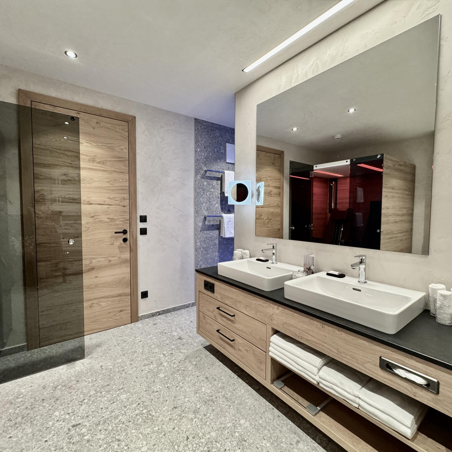 Modern bathroom at Familienresort Buchau with double sinks and wooden accents