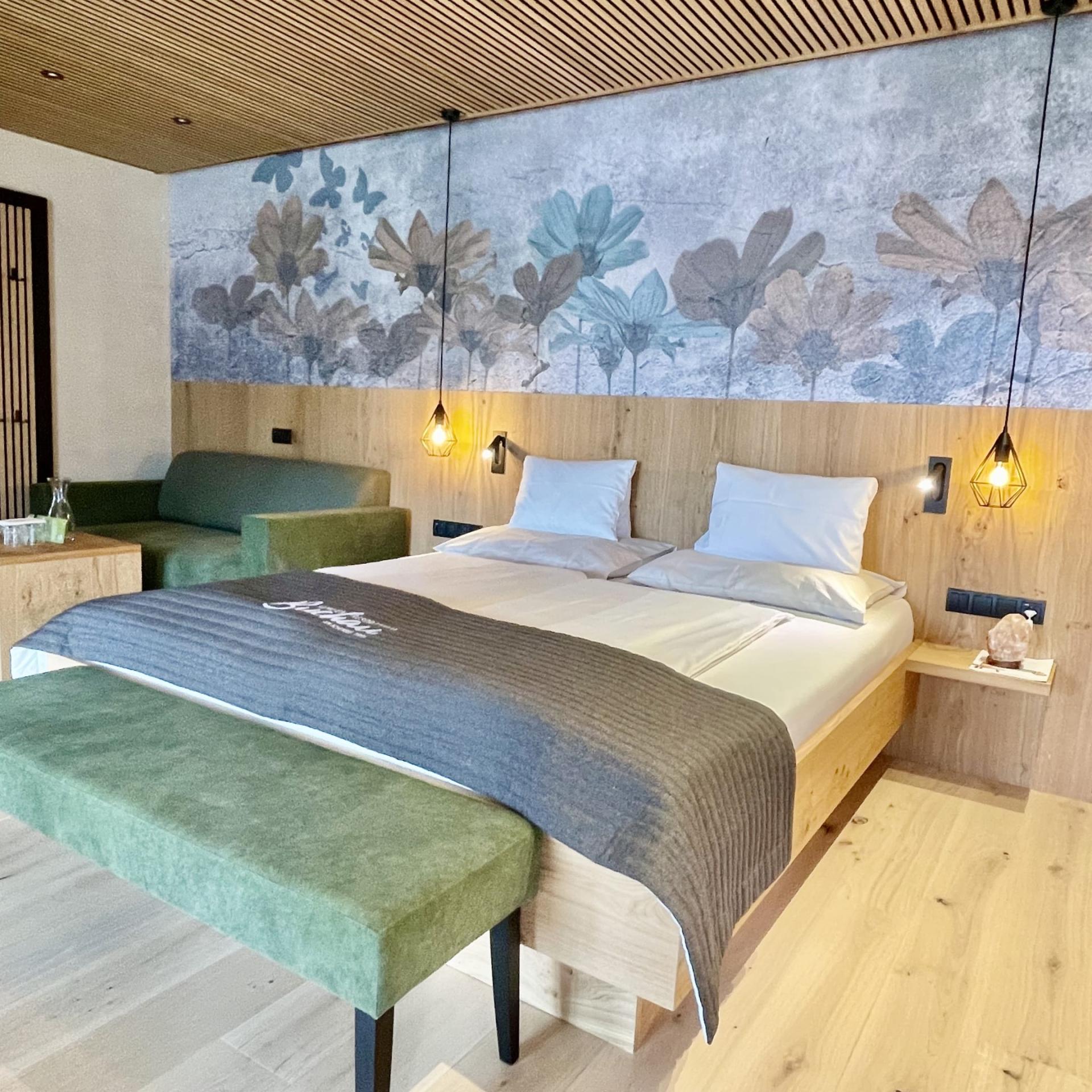 Modernes Zimmer im Familienresort Buchau mit Doppelbett und Sitzbereich