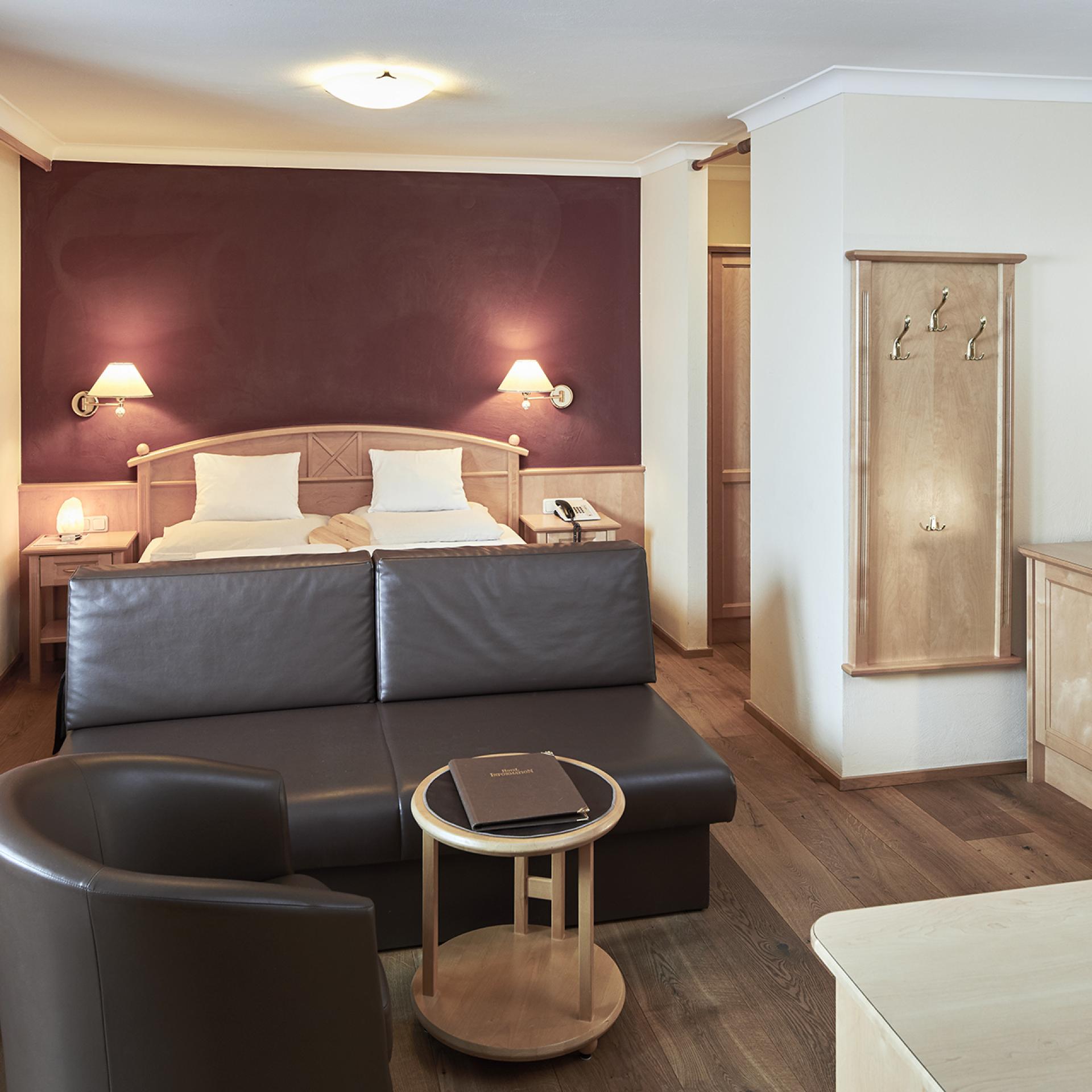 Cozy room with bed and seating area at Familienresort Buchau