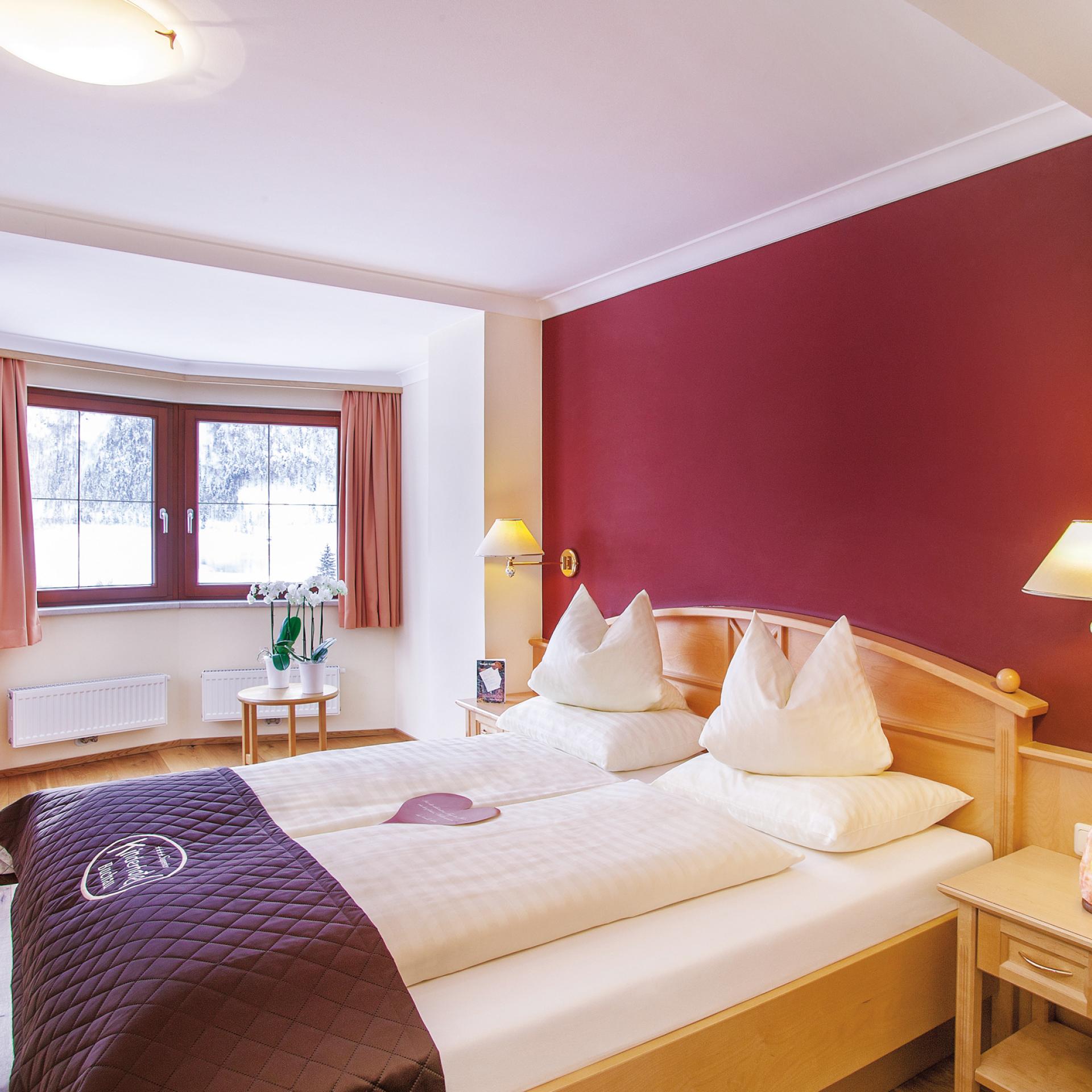 Gemütliches Schlafzimmer im Familienresort Buchau mit Doppelbett und Fenster