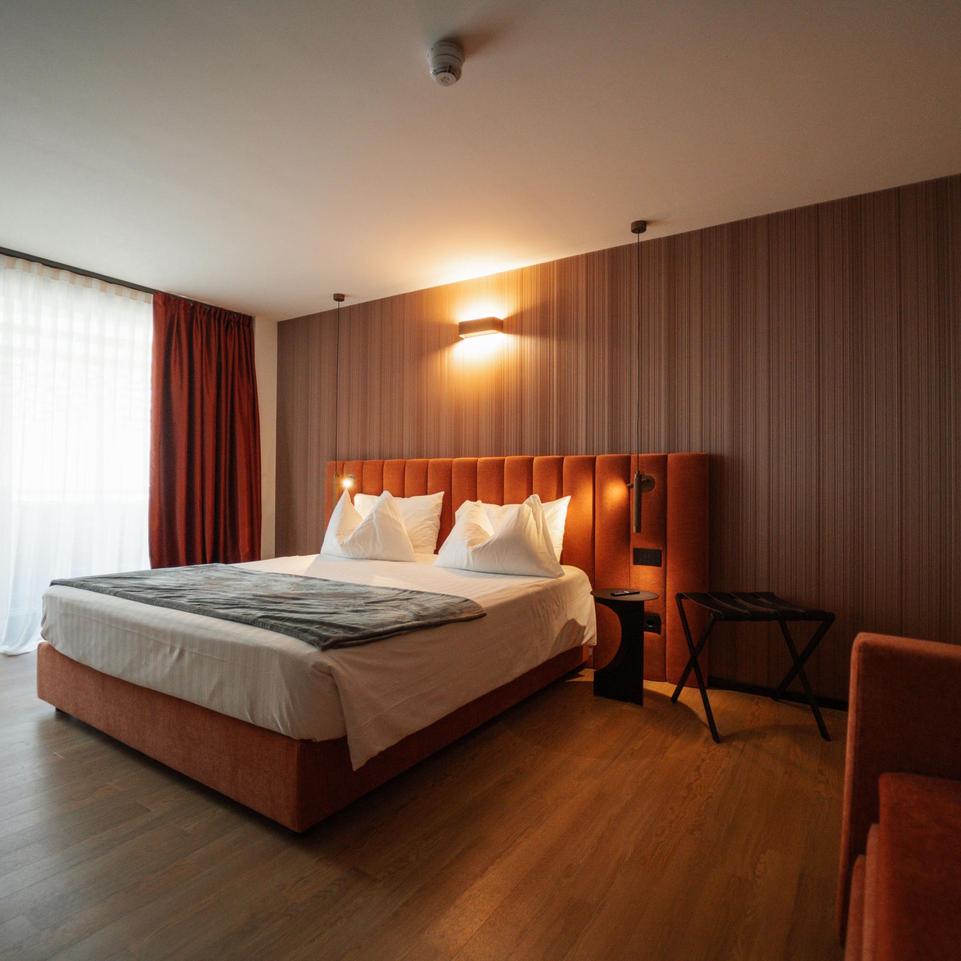Camera moderna all'Hotel San Giacomo con pareti in legno e letto confortevole