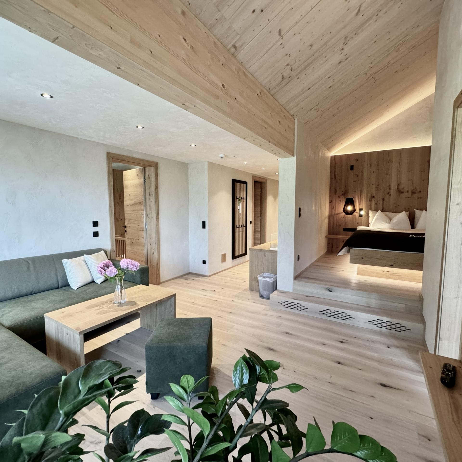 Modern suite at Familienresort Buchau with sofa, wooden furniture, and bedroom